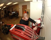 MINOT AIR FORCE BASE, N.D. -- Airman 1st Class Daryl Heberling, an aircrew flight equipment apprentice with the 5th Operations Support Squadron, works with fellow apprentice Airmen 1st Jaime Wood to regulate the pounds per square inch on an air compressor here Feb. 12. The air compressor is used during inspection of the life raft in an ML-4 survival kit, which contains essential items for pilots during flights.. (U.S. Air Force photo by Airman 1st Class Sharida Bishop)