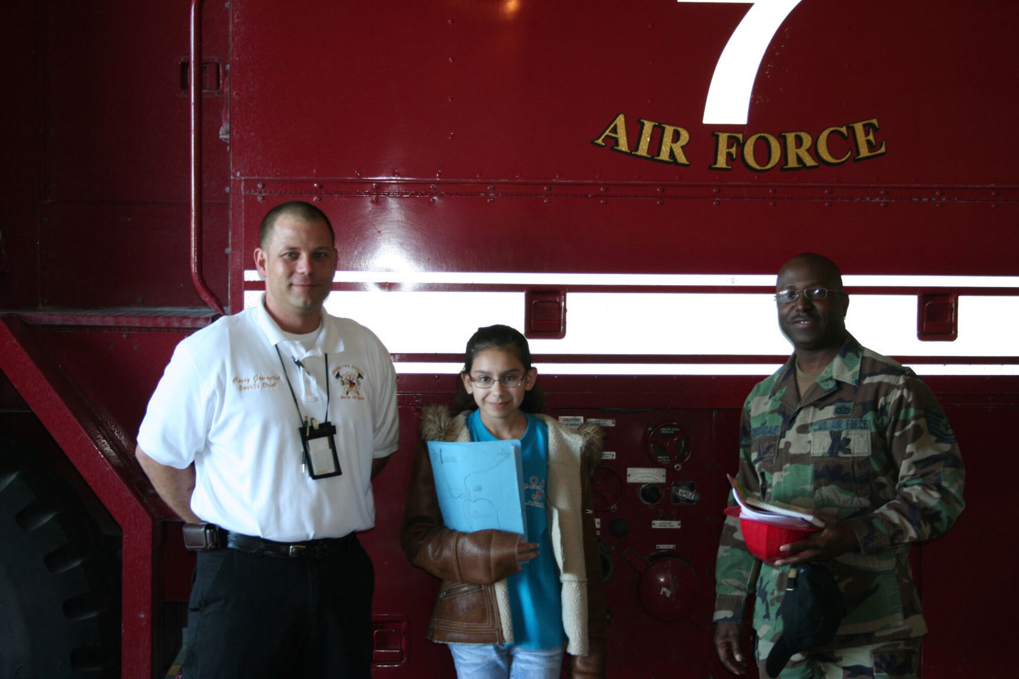 Corey R. Grumelot, 496th Air Base Squadron assistant fire chief, Carrissa Warren, Sevilla Elementary DoDDS Student, and Master Sgt. Daniel H. Crossdale, 496th ABS Civil Engineering Flight, took a tour of the fire station at Moron Air Base, Spain. (Photo by Staff Sgt. Joshua K. Mueller) 