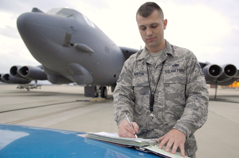 BARKSDALE AFB, LA - Staff Sergeant Benjamin Norton, 2d Aircraft Maintenance Unit, leaves his mark on a B-52H pre-flight checklist signifying a perfectly maintained plane. Sgt. Norton is the crew chief responsible for the planes perfect checklist, an event which only happens around once every ten years. (USAF Photo By SSgt Stephen J. Otero, RELEASED)