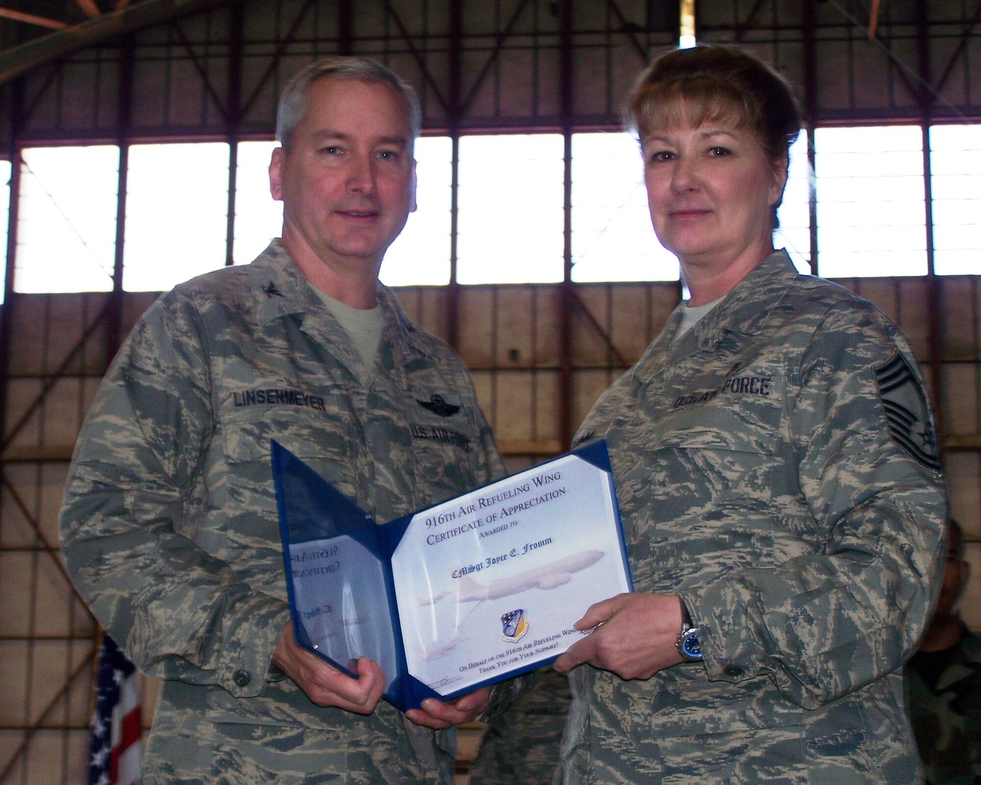 SEYMOUR JOHNSON AIR FORCE BASE, N.C. -- Chief Master Sgt. Joyce Fromm (right)  receives a Get One award from Col. Fritz Linsenmeyer, wing commander of the 916th Air Refueling Wing. The Get One award is presented by the Reserve wing's recruiting office to current members who have made a referral resulting in a new member joining the Air Force Reserve. U.S. Air Force photo/Tech. Sgt. Ian Gardner