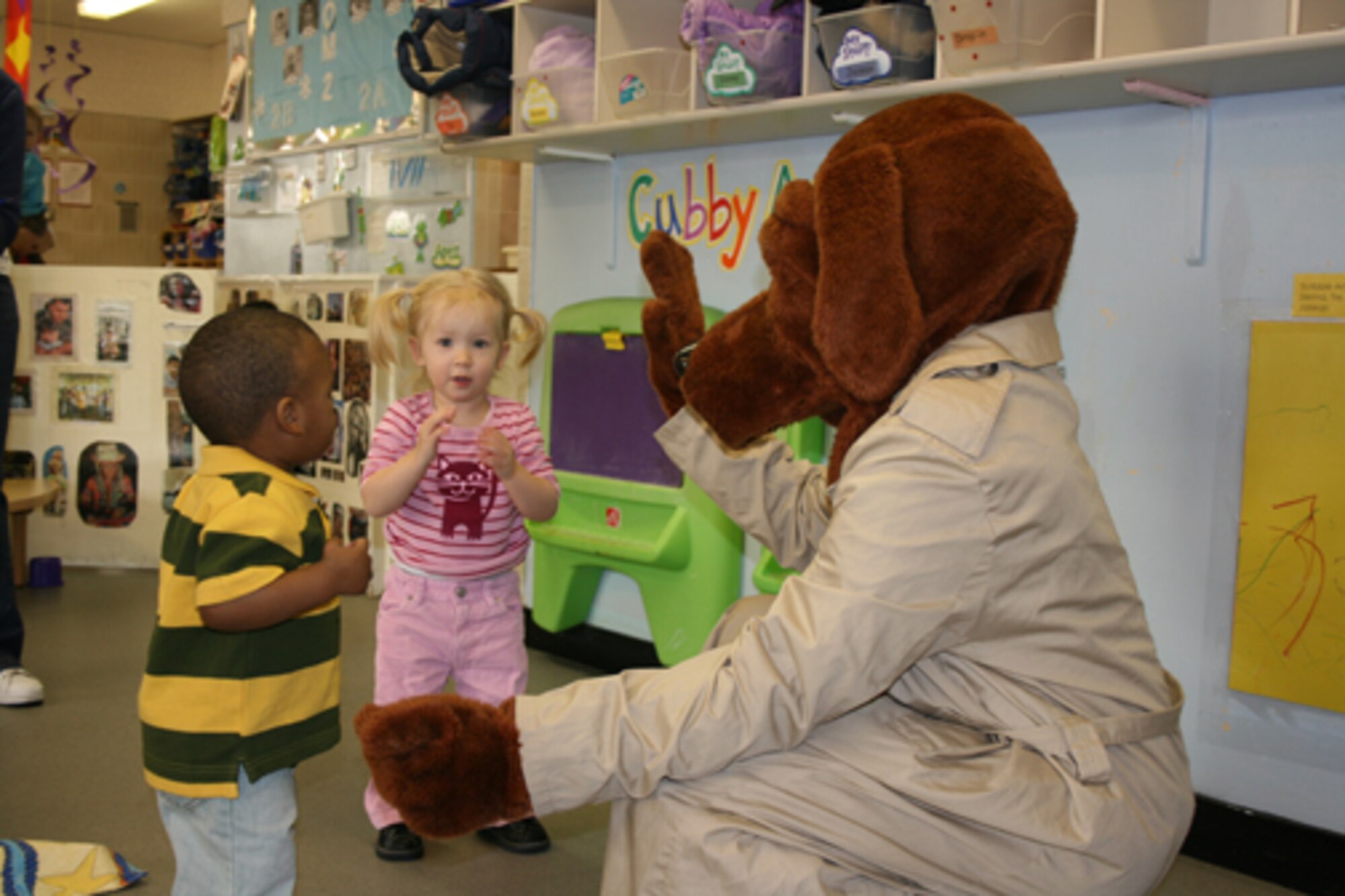 McGruff the Crime Dog gives a high five to Jaisen Kenner and Ana Kritnik during a visit to the Alconbury Child Development Center. Memebers of the 423rd Security Forces Squadron visited the CDC and demonstrated their equipment and met with the kids.