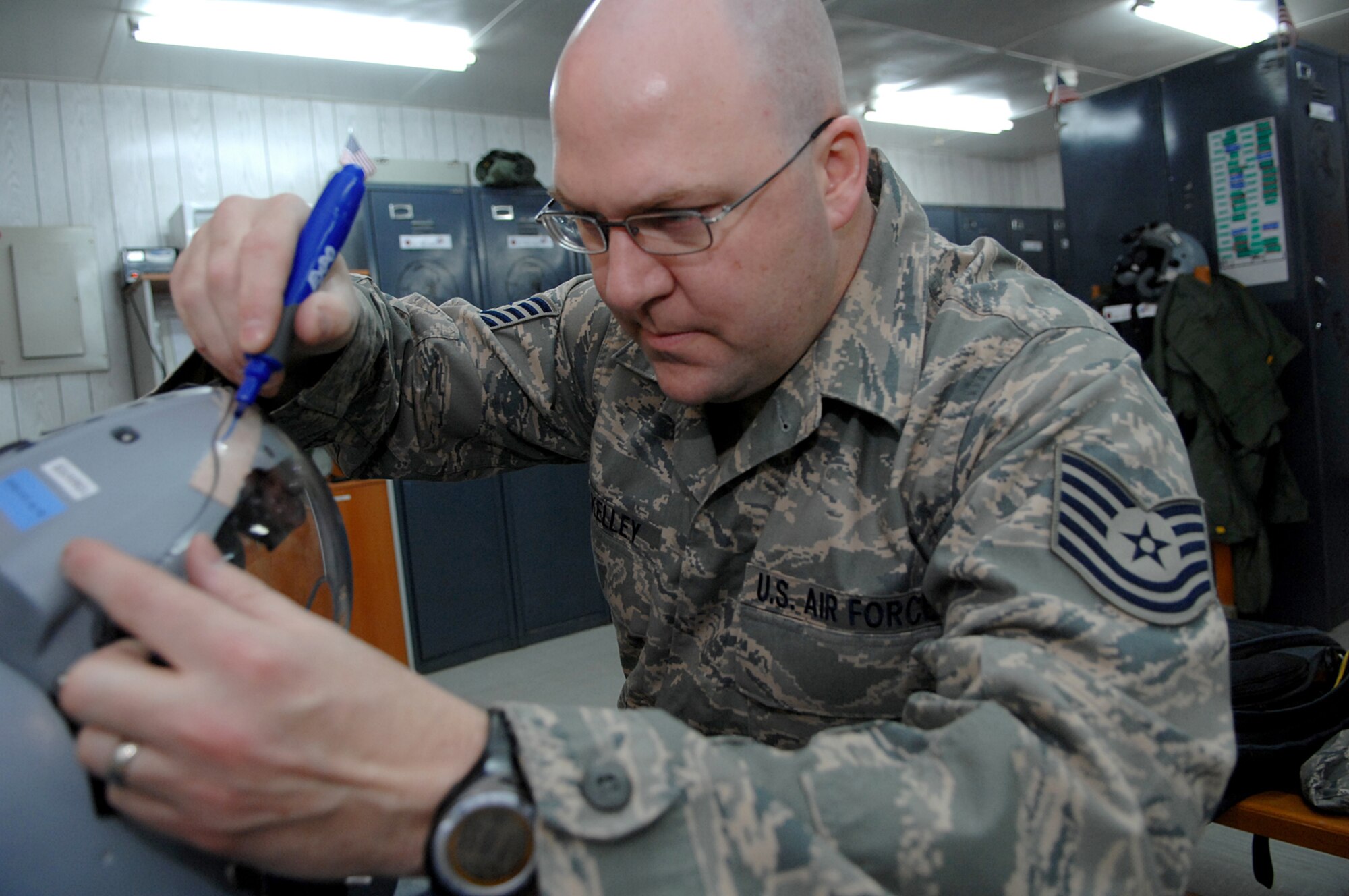 BALAD AIR BASE, Iraq -- Tech. Sgt. Christopher Kelley, 23rd Expeditionary Fighter Squadron air crew flight equipment technician, marks a helmet visor before grinding it down to the right shape here, Feb. 14. The clear visor is used for nighttime missions and can take up to two hours to custom fit to F-16 Fighting Falcon pilots. Sergeant Kelley is deployed from Spangdahlem Air Base, Germany. (U.S. Air Force photo/ Senior Airman Julianne Showalter)