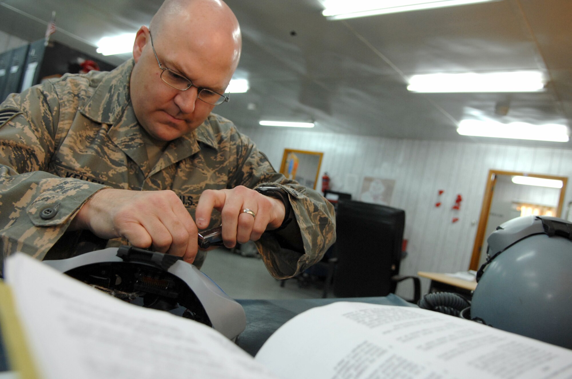 BALAD AIR BASE, Iraq -- Tech. Sgt. Christopher Kelley, 23rd Expeditionary Fighter Squadron air crew flight equipment technician, replaces the cathode ray tube assembly inside of a helmet visor here, Feb. 14. The cathode ray tube projects a visual display inside the helmet. The 23rd EFS was the first fighter squadron to deploy to the area of operation with the joint helmet mounted cueing system in June 2006. Sergeant Kelley is deployed from Spangdahlem Air Base, Germany. (U.S. Air Force photo/ Senior Airman Julianne Showalter)