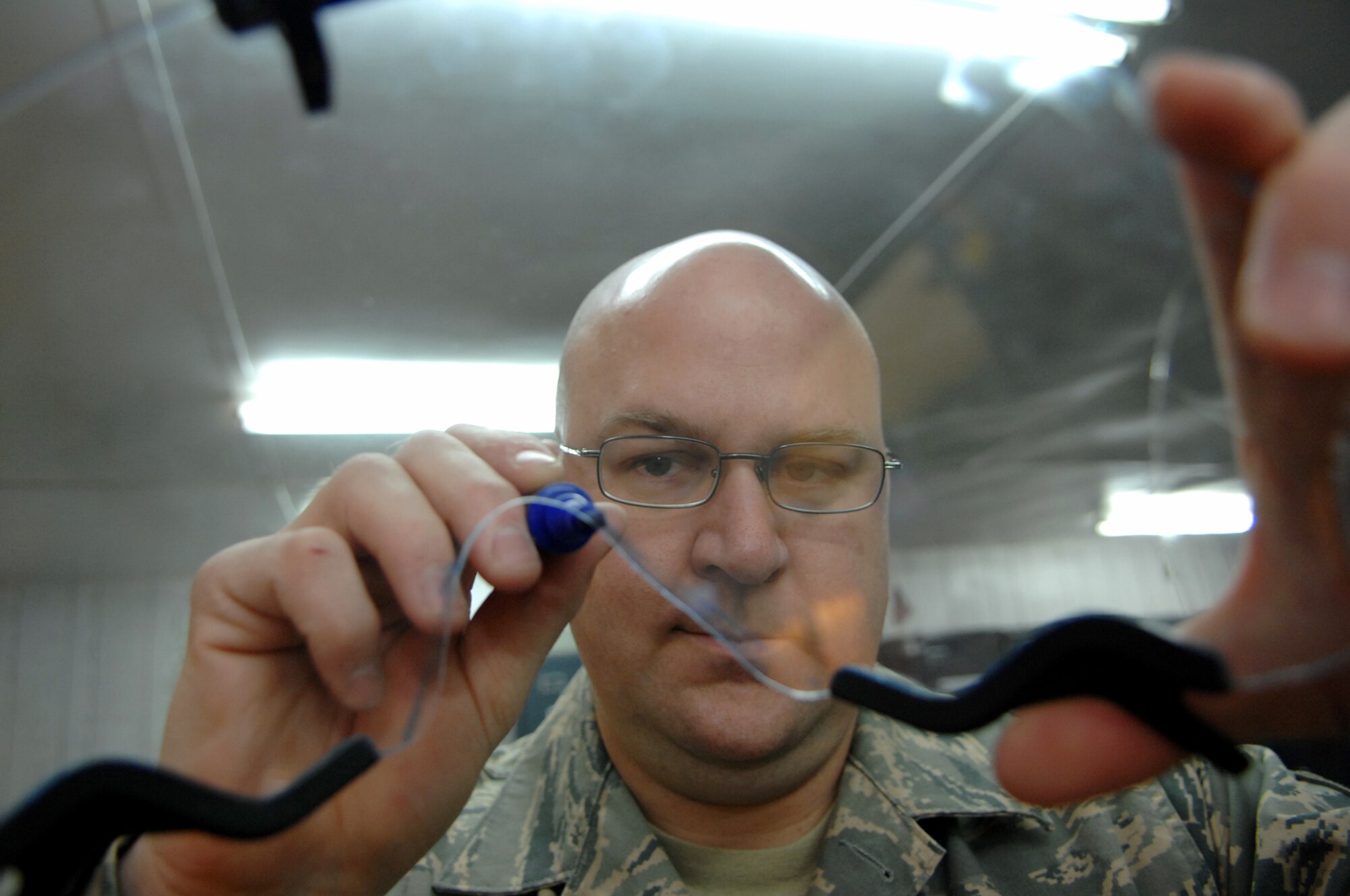 BALAD AIR BASE, Iraq -- Tech. Sgt. Christopher Kelley, 23rd Expeditionary Fighter Squadron air crew flight equipment technician, marks a helmet visor before grinding it down to the right shape here, Feb. 14. Each helmet visor is custom fit to the F-16 Fighting Falcon pilot who will wear it. Sergeant Kelley is deployed from Spangdahlem Air Base, Germany. (U.S. Air Force photo/ Senior Airman Julianne Showalter)
