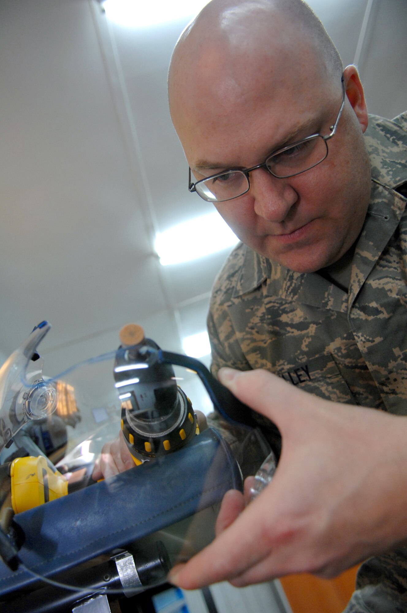 BALAD AIR BASE, Iraq -- Tech. Sgt. Christopher Kelley, 23rd Expeditionary Fighter Squadron air crew flight equipment technician, grinds down a helmet visor for an F-16 Fighting Falcon pilot here, Feb. 14. The technicians grind away just enough to ensure that the pilot can see the heads up display clearly and completely. A cathode ray tube projects the heads up display inside the helmet. Sergeant Kelley is deployed from Spangdahlem Air Base, Germany. (U.S. Air Force photo/ Senior Airman Julianne Showalter)