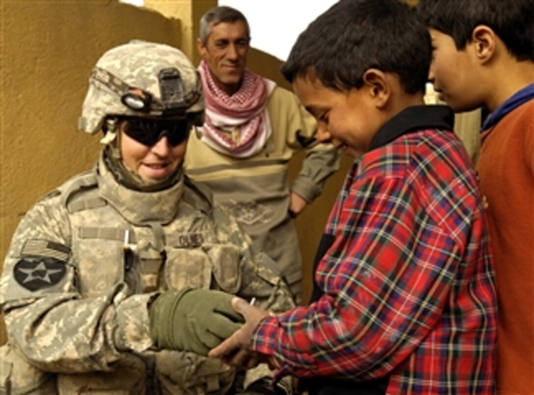 U.S. Army Cpl. Marvin Olnes hands out candy and treats to Iraqi children in the village of Al Hakeem in Baqubah, Iraq, Feb. 13, 2008. Olnes is assigned to the 2nd Infantry Division. 