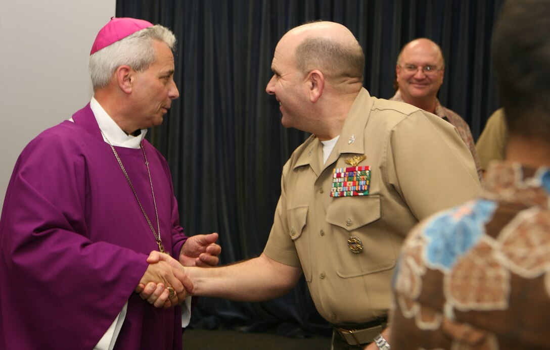 CAMP H.M. SMITH, Hawaii -- Most Reverend Joseph W. Estabrook, D.D., Auxiliary Bishop of Archdiocese of the Military Services, shakes hands with Col. James L. Stalnaker, Chief of Staff, U.S. Marine Corps Forces Pacific, after Roman Catholic mass, Feb. 15 in the chapel here.  The bishop intends to visit US troops and local churches throughout the region.  His intent is to better the partnership of the Roman Catholic churches.  He also wants to push youth programs in the region.