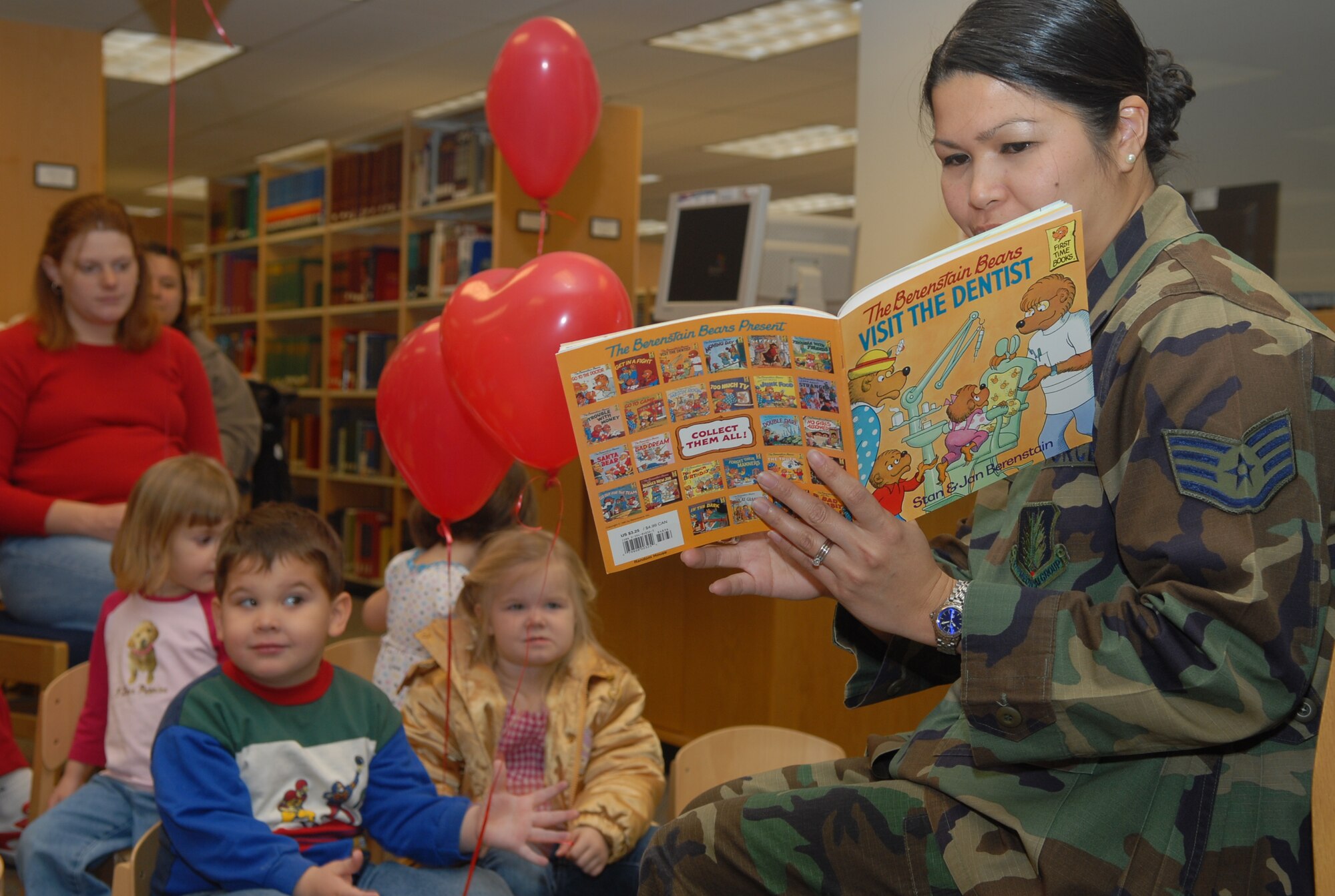 ALTUS AIR FORCE BASE, Okla. -- Staff Sgt. Rowena Ennis, 97th Medical Group dental technician, reads a book about going to the dentist's office to young children during a National Children's Dental Health Month event at the Base Library. (U.S. Air Force photo/Airman 1st Class Cherice Bryant)