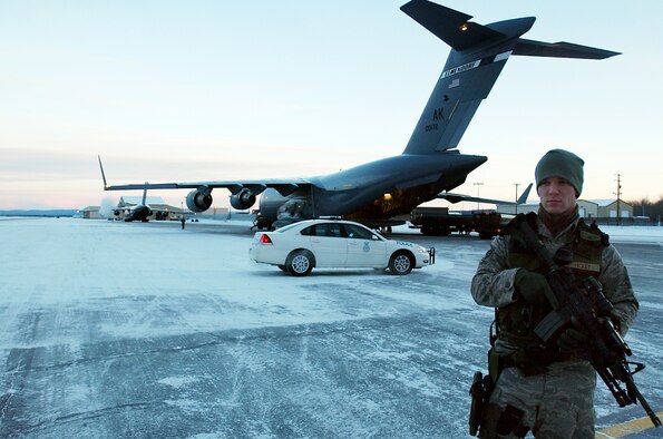 Senior Airman Brad Hickey, 354th Security Forces Squadron, stands guard in below-zero temperatures, providing security for the two C-17 Globemaster IIIs, that are transporting members and equipment of the Army's First Stryker Brigade Combat Team of the 25th Infantry Division, 1st Battalion 24th Infantry Regiment, Charlie Company from Fort Wainwright, Alaska to South Korea in support of the Foal Eagle exercise. It is the first time the Air Force and the Army in Alaska have used joint assets to project combat power protection out of Alaska. The C-17 Globemaster III and its crew members are from the 517th Airlift Squadron, Elmendorf Air Force Base, Alaska. (U.S Air Force photo by Staff Sgt Eric T. Sheler)