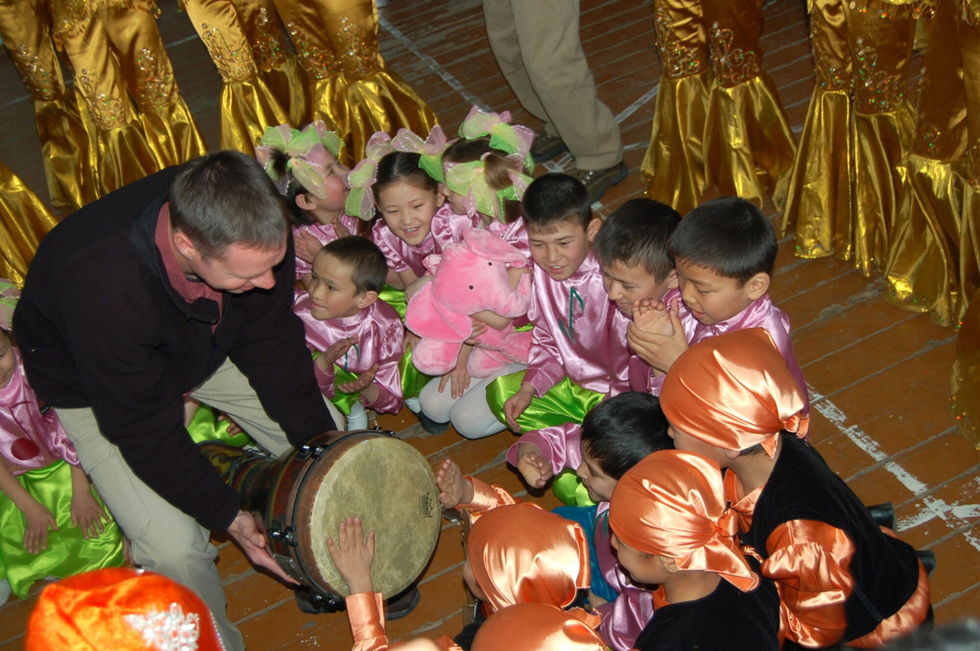 Master Sgt. Jeremy Laukhuf, a  bass guitar player with U.S. Central Command Air Forces Band 'Live Round' lets children at the Bishkek Boarding School for the Deaf beat on the djimbe drum during one of the band's outreach visits to a local school. The children were able to feel the music through the vibrations in the floor and through touch. Live Round performed for Manas Air Base Airmen and local villages and schools during their eight-day trip to Kyrgyzstan. (U.S. Air Force photo/Senior Master Sgt. Greg Wade)