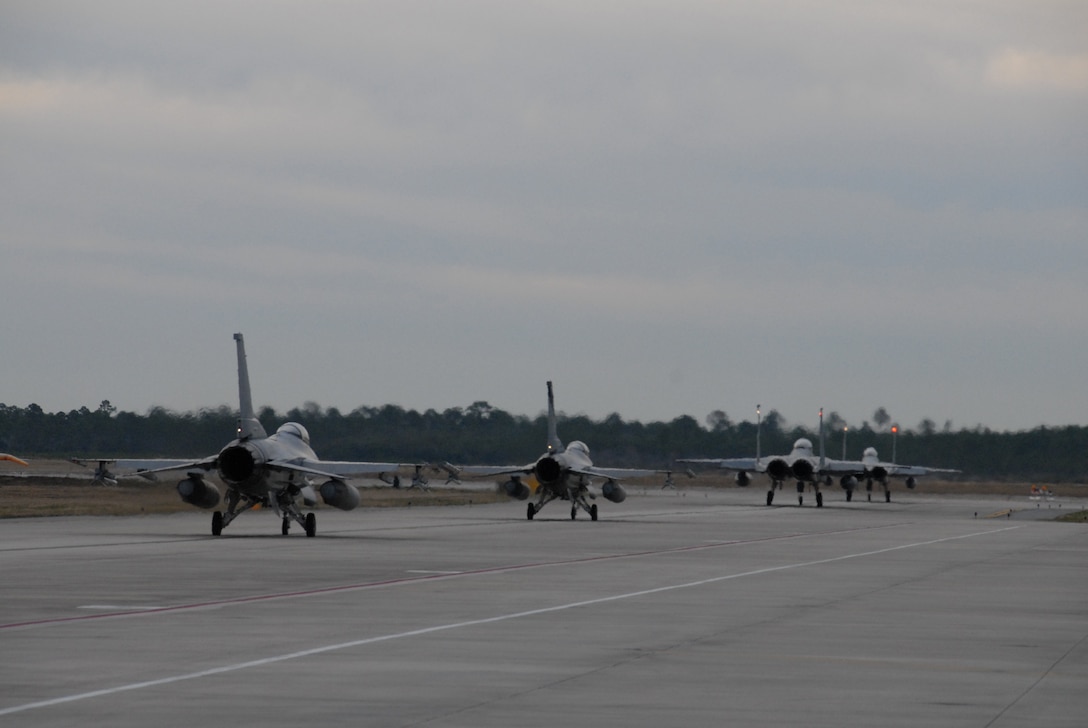 Two F-16s from the 194th Fighter Squadron, 144th Fighter Wing, Fresno, CA, taxi out to the runway behind two F-15s from Tyndall AFB for an early morning training mission during Combat Archer, a weapon systems academics exercise, at Tyndall AFB, FL on February 5, 2007.  (U.S. Air Force photo by SMSgt Chris Drudge)(released)
