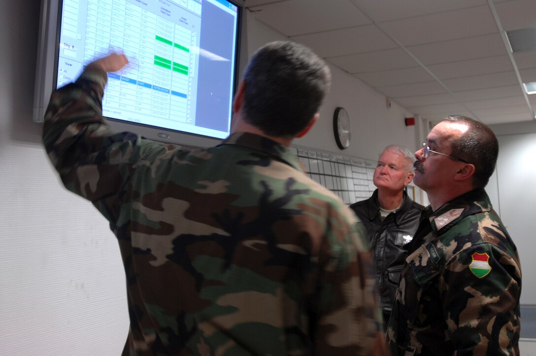 Lt. Col. Peter Tremblay, the 435th Logistics Readiness Squadron commander (left), explains to Lt. Gen. Laszlo Tombol, the Hungarian Joint Forces Command commander, how the mission screen in the Joint Mobility Processing Center works during a tour of the center Feb. 6 at Ramstein Air Base, Germany. (U.S. Air Force photo/Airman 1st Class Kenny Holston) 