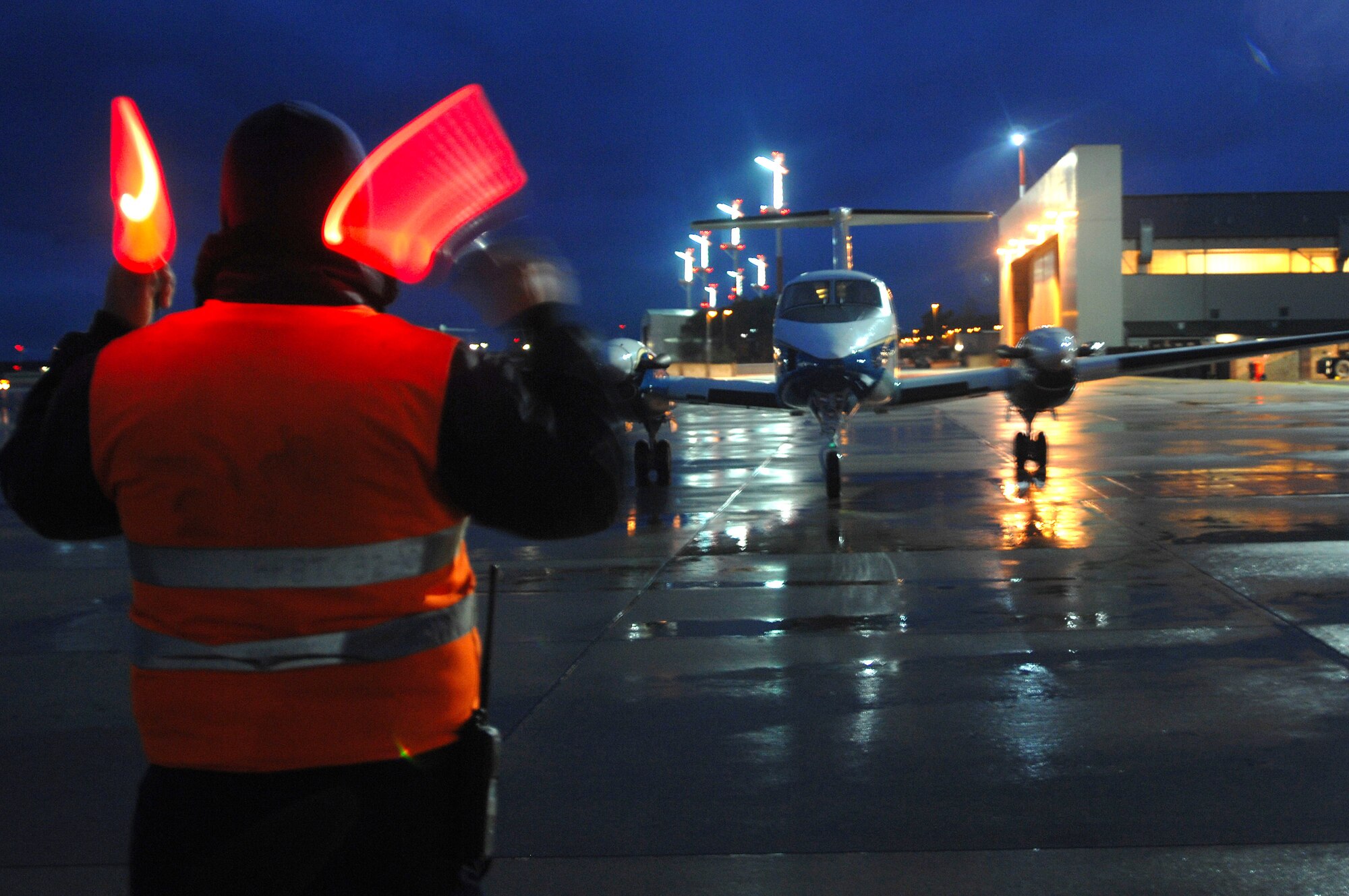 David Moore, Ramstein transit alert, guides a C-20 distinguished visitor's aircraft to its parking spot Feb 5, on the Ramstein Air Base flightline. Lt. General Laszlo Tombol, Commander Hungarian Joint Forces Command, happen to be the distinguished visitor. Lt. Gen. Rod Bishop 3rd Air Force Commander and the 3rd Air Force played host to the Hungarian general and discussed important topics helping both countries make head way on the war on terror. (U.S. Air Force Photo/Airman 1st Class Kenny Holston)