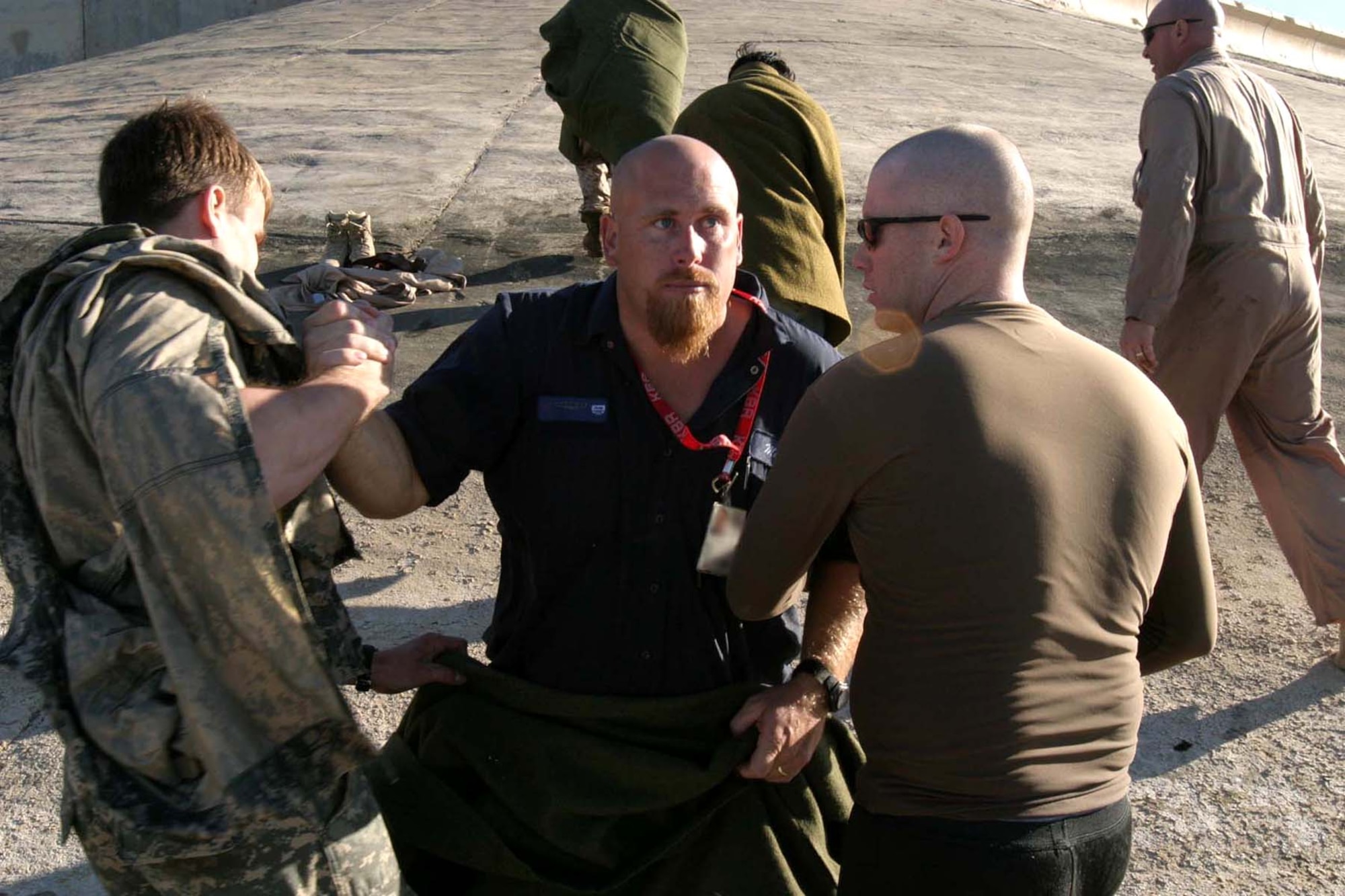 Air Force Office of Special Investigations Special Agent Jim Collins (right) comforts a civilian contractor after rescuing him after the contractor jumped out of a Marine CH-46 Sea Knight helicopter that crash landed Dec. 3, 2006, in Lake Quadisiya in Iraq. Special Agent Collins and several others witnessed the crash in the 50-degree waters of the lake. (U.S. Marine Corps photo/Cpl. Luke Blom) 
