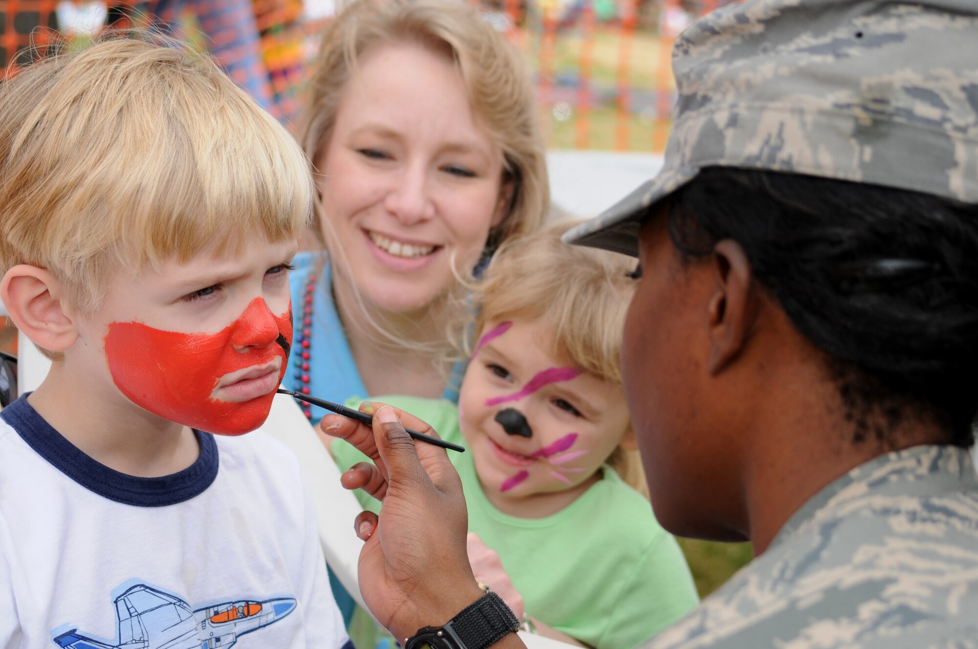 Dominic Colella, 6, has his face painted by Airman 1st Class Kimberly Davis as his mom, Michelle, and his 3-year-old sister, Desiree, look on during a party for family members of deployed Keesler Airmen at the Biloxi Town Green during the Gulf Coast Carnival Association Mardi Gras parade Feb. 5.  The children’s father, Capt. Robert Colella, returns from a six-month deployment to Southwest Asia in March.  (U.S. Air Force photo by Kemberly Groue)