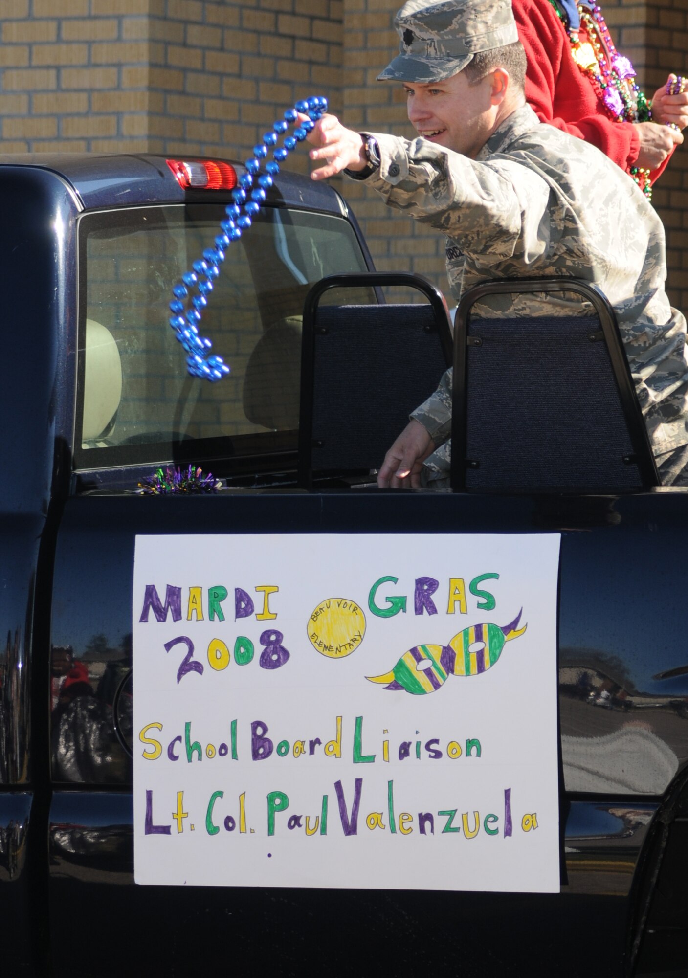 Lt. Col. Paul Valenzuela, 81st Mission Support Squadron commander, tosses beads to students during the Beauvoir Elementary School Mardi Gras parade in Biloxi Feb. 1.  (U.S. Air Force photo by Kemberly Groue)
