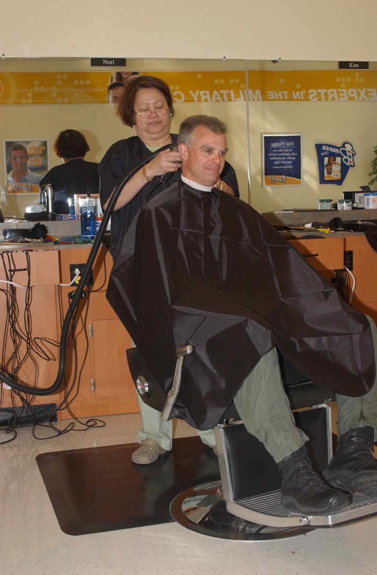 Lt. Col. Keith Gibson enjoys his haircut from Nori Eaton Friday at the barber shop, located inside the new AAFES complex here.  (U.S. Air Force photo by Airman 1st Class David Salanitri)