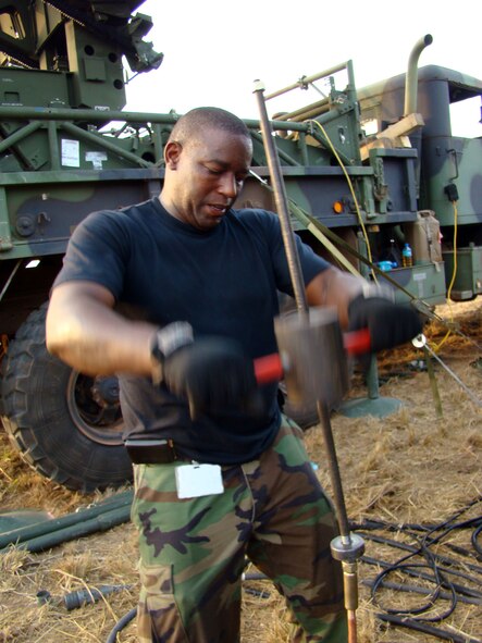Tech. Sgt. Andrew Binns drives a ground rod for a radar shelter into the ground as he and his teammates set up communications equipment Feb. 14 in Accra, Ghana. The Airmen are part of a multiservice team providing communications capabilities in support of President George Bush's visit to the West African nation. Sergeant Binns is a ground radar systems craftsman from the 603rd Air Control Squadron at Aviano Air Base, Italy. (U.S. Air Force photo/Tech. Sgt. Denise Johnson)