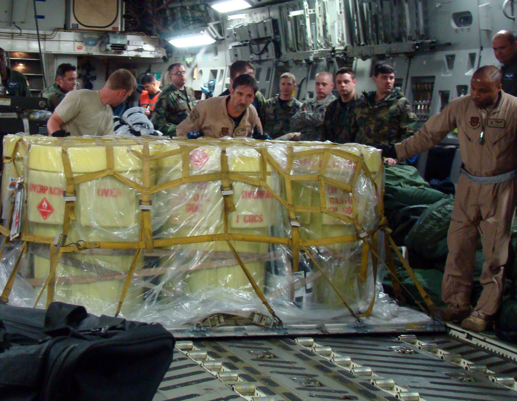 Passengers clear a path as Tech. Sgt. Lee Fletcher (left) assists Tech. Sgt. Fred Fox guide a pallet toward the cargo ramp of a C-17 Globemaster III Feb. 12 at Ramstein Air Base, Germany. The crew transported the cargo and passengers from Ramstein AB to Accra, Ghana, in support of President George Bush's visit to the West African country. Members of the Air Force, Army, Navy and Marine Corps are deploying to Africa to provide forward operating support for President Bush's visit to the continent. Sergeant Fletcher is an aerial porter with the 819th Global Support Squadron from McGuire Air Force Base, N.J., and Sergeant Fox is a loadmaster from the 437th Airlift Wing from Charleston AFB, S.C. (U.S. Air Force photo/Tech. Sgt. Denise Johnson) 
