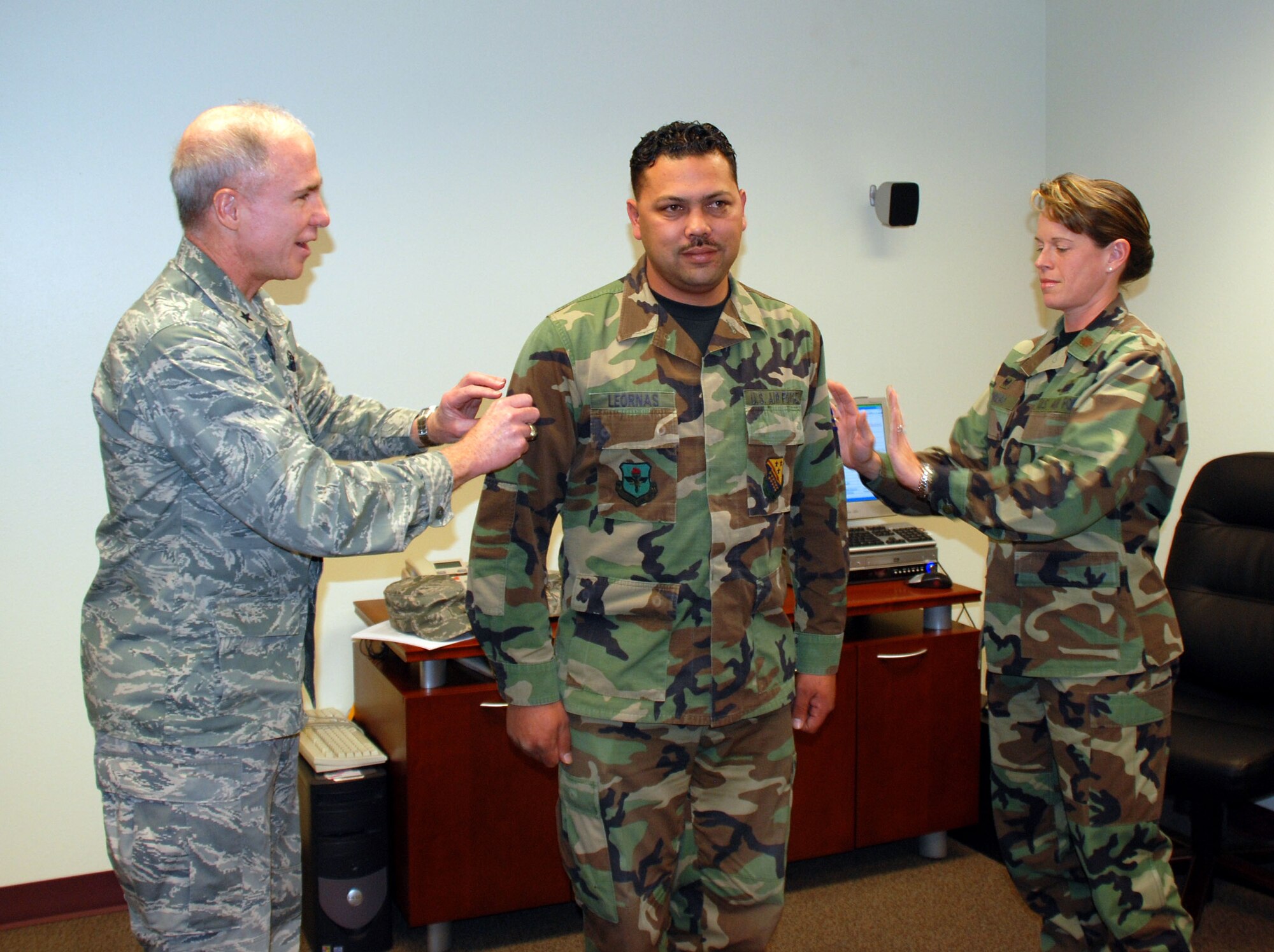Brig. Gen. Richard Devereaux, 82nd Training Wing commander, and Maj. Jenniffer Romero, 82nd Communication Squadron commander, place a new set of stripes on Tech. Sgt. Donald Leornas, a radio maintenance technician with the 82nd CS. Sergeant Leornas was promoted to the rank of technical sergeant under the Stripes for Exceptional Performers program. (U.S. Air Force photo/Airman 1st Class Jacob Corbin)