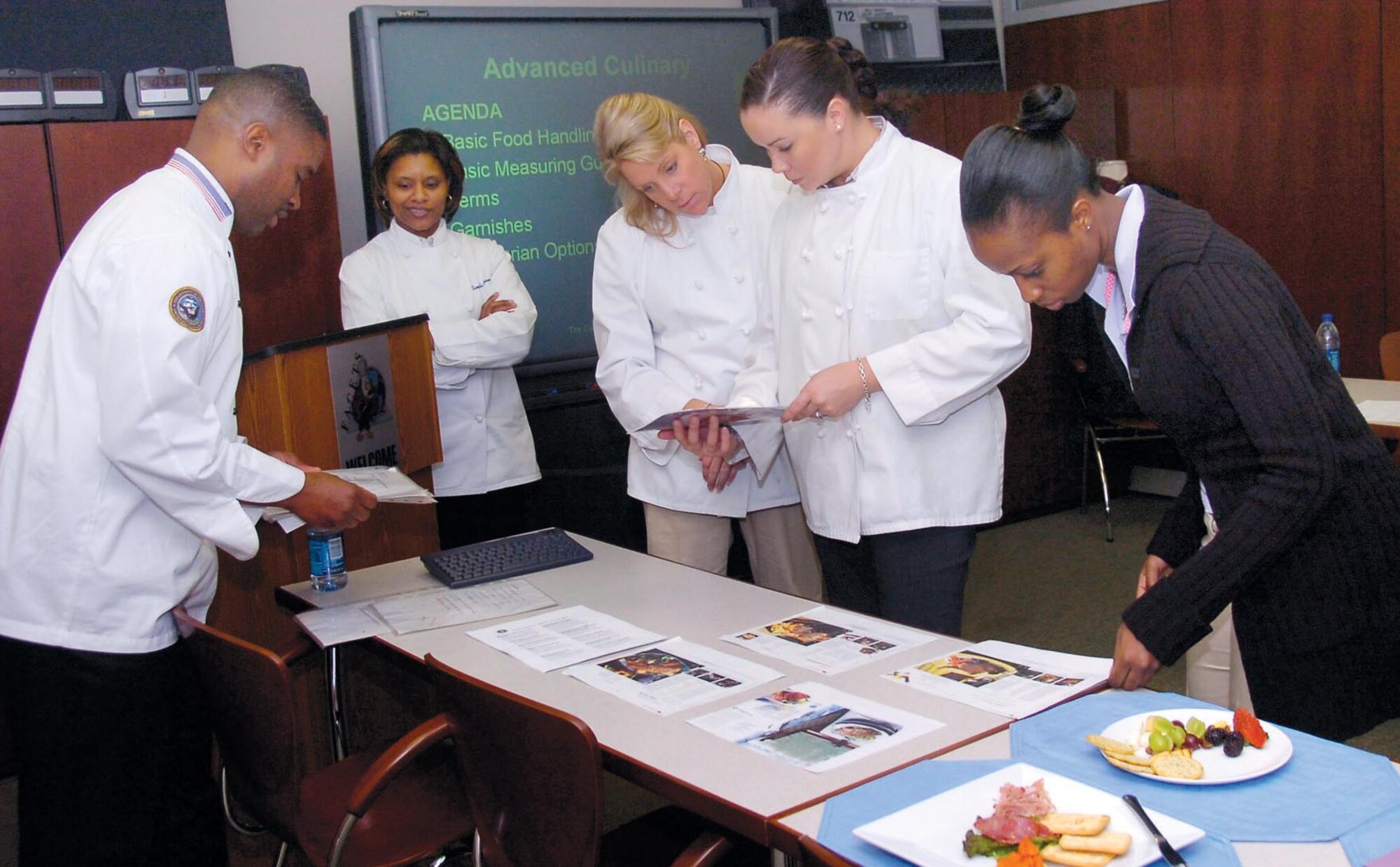 Navy Culinary Specialist Chief Petty Officer Dexter Johnson, left, shares some recipes he uses at the White House with the the Executive Airlift Training Center instructors and students during day one of the Advanced Culinary Class which ran Jan. 28 through  Feb. 1.
(US Air Force/Bobby Jones)