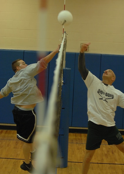 MOODY AIR FORCE BASE, Ga. -- Staff Sgt. Timothy Gallagher, 822nd Security Forces Squadron and Chief Master Sgt. Stephen White 23rd Security Forces Squadron superintendent, jump to hit a volleyball over the net during a Chiefs and First Sergeants vs. Airman Leadership Class 08-B volleyball game Feb. 13 here. The chiefs and first sergeants became the victors winning all four games played. (U.S. Air Force photo by Airman 1st Class Brittany Barker)