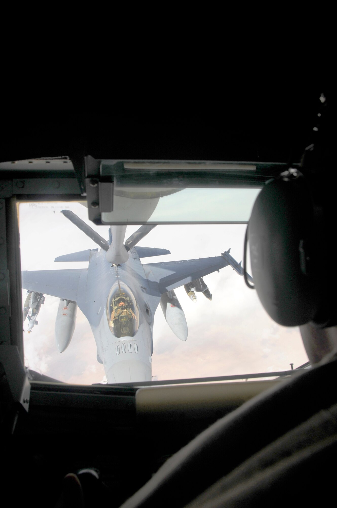 Airman 1st Class Jonathan Fleming performs an in flight refuel from the boom seat of a KC-135 Aircraft for an F-16 fighter aircraft Feb. 14. Airman Fleming is a member of the 340th Expeditionary Air Refueling Squadron and is deployed from Grand Forks Air Force Base. (U.S. Air Force Photo/Senior Airman Domonique Simmons)
