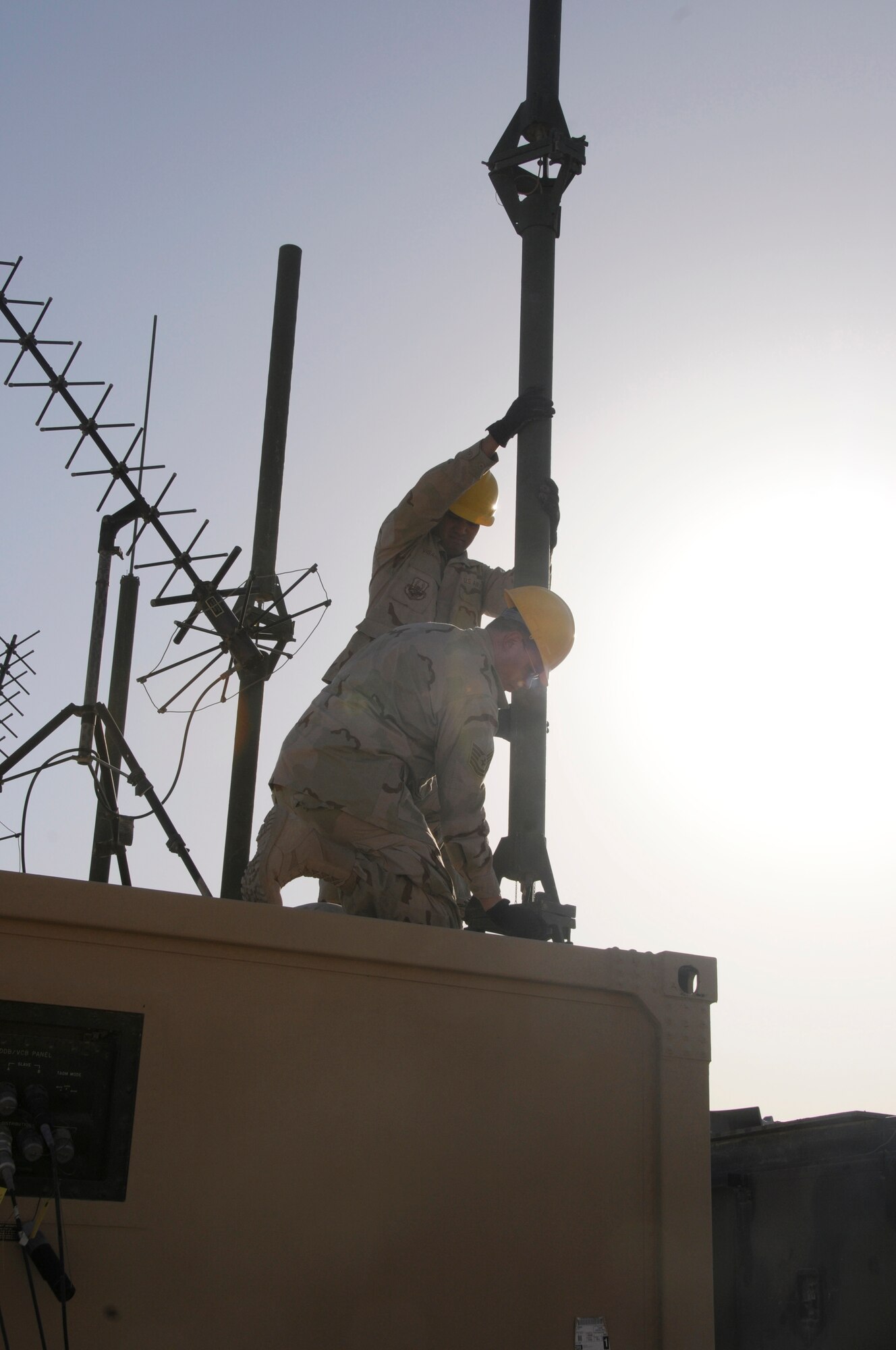 Tech. Sgt. Kenneth Paquin and Senior Airman Arturo Vissarraga repair a communications structure inside the 71st Expeditionary Air Control compound. (U.S. Air Force photo/Domonique Simmons)