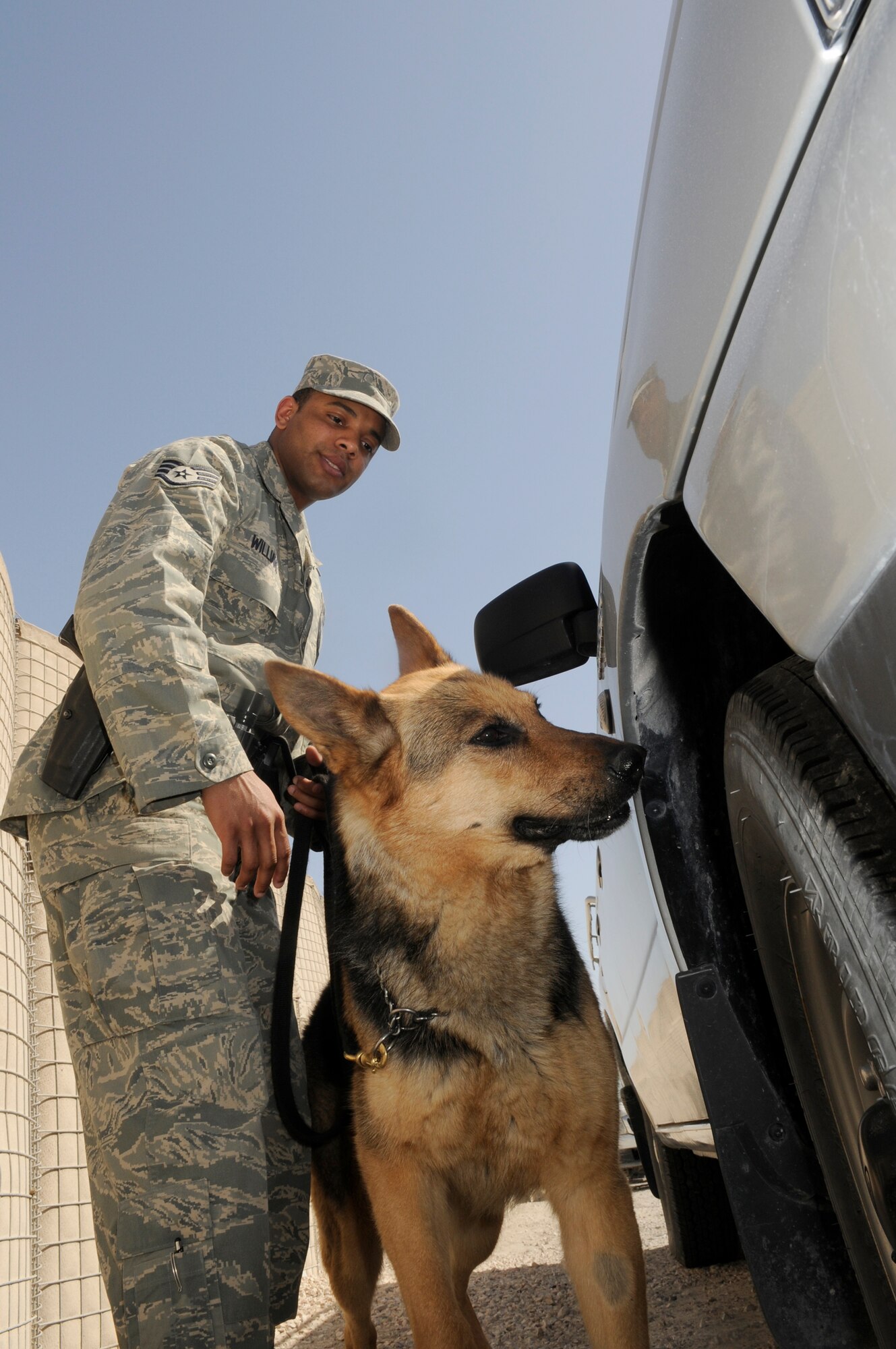 Staff Sgt. Kenneth Williams, 379th Expeditionary Security Forces, conducts random antiterrorism measures with his military working dog partner Bruno at a Southwest Asia air base Feb 13. Sergeant Williams and Bruno remain ready by constantly training while on foot patrol. He is from San Diego, CA and both are deployed from Nellis Air Force Base, Nev. (U.S. Air Force photo/Tech. Sgt. Johnny L. Saldivar)
