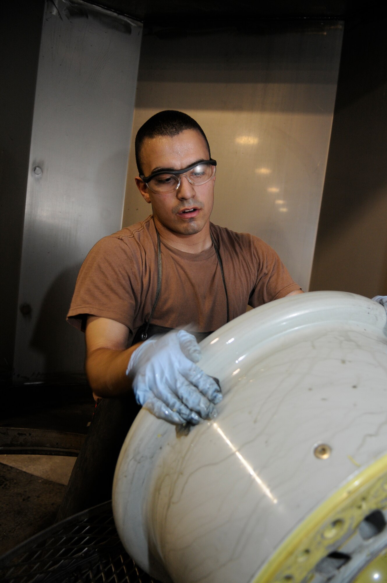 Airman 1st Class Jeremy Mestas, 379th Expeditionary Maintenance Squadron, removes grudge from a KC-135 wheel at a Southwest Asia air base Feb 13. Airman Mestas completely breaks down, inspects, and rebuilds aircraft wheels in less than 3 hours . He is from Las Vegas, Nev. deployed from Ramstein Air Base, Germany. (U.S. Air Force photo/Tech. Sgt. Johnny L. Saldivar)
