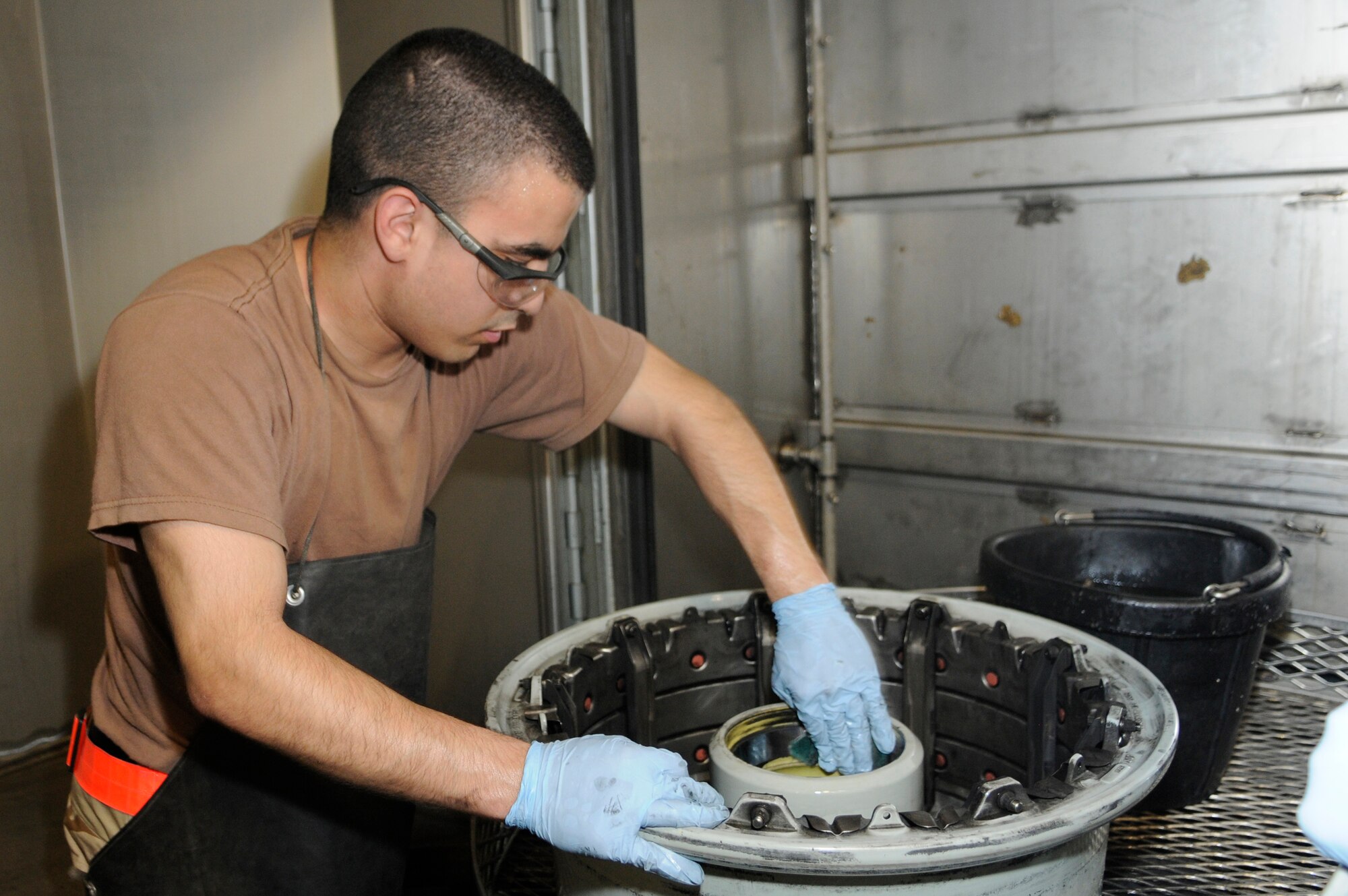 Airman 1st Class Jeremy Mestas, 379th Expeditionary Maintenance Squadron, removes grudge from a KC-135 wheel at a Southwest Asia air base Feb 13. Airman Mestas completely breaks down, inspects, and rebuilds aircraft wheels in less than 3 hours . He is from Las Vegas, Nev. deployed from Ramstein Air Base, Germany. (U.S. Air Force photo/Tech. Sgt. Johnny L. Saldivar)