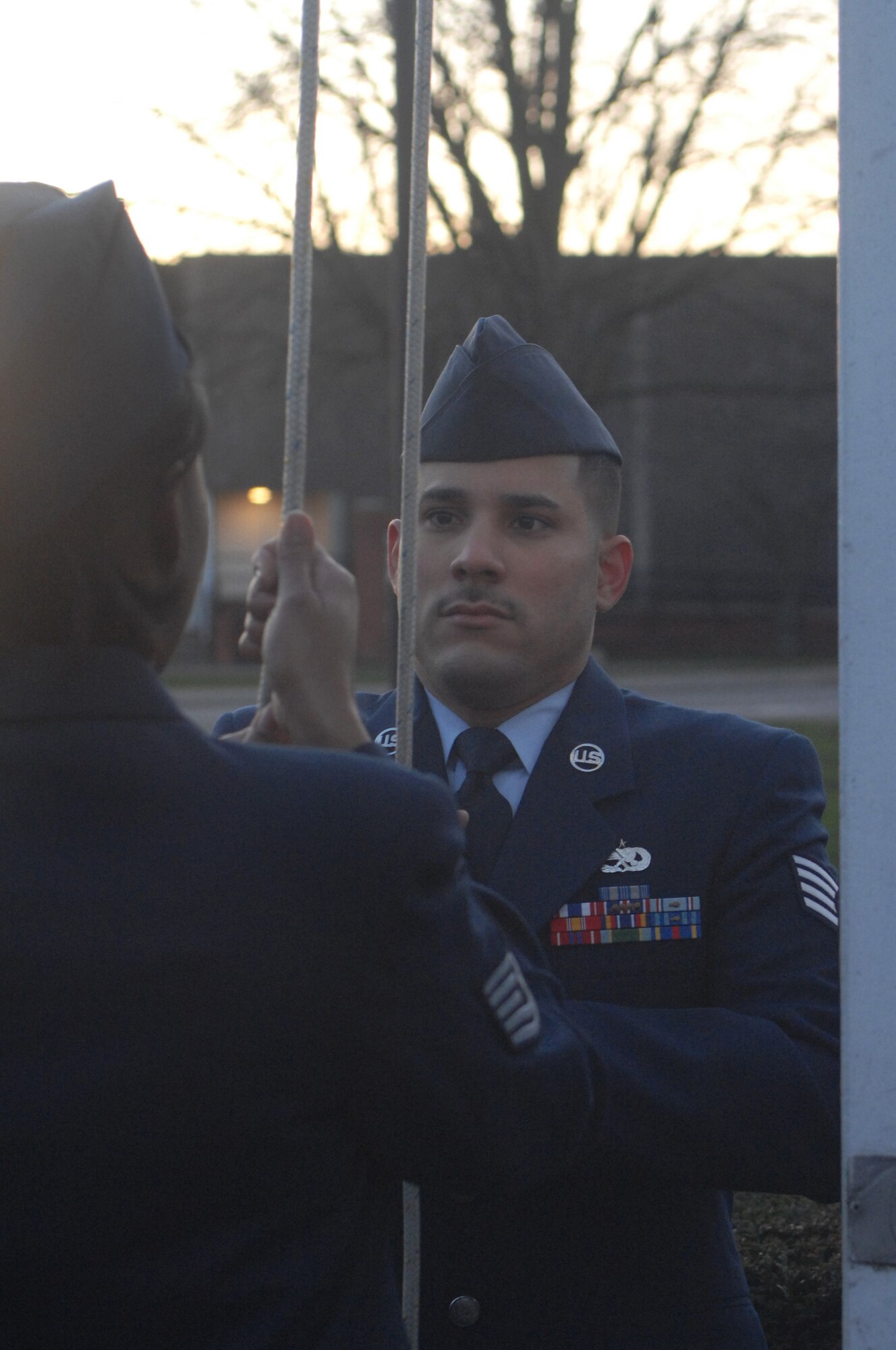 Staff Sgt. Luis Mercado, 352nd Maintenance Squadron MC-130 Propulsion Section NCOIC, lowers the U.S. flag during a retreat here Jan. 31. The retreat ceremony was facilitated by volunteers of Team 56. Team 56 began performing monthly retreat ceremonies last fall in an effort to get more involved in base events. During this retreat, 100th Air Refueling Wing Commander Col. Eden Murrie presided. (U.S. Air Force photo by Senior Airman Teresa Hawkins) 