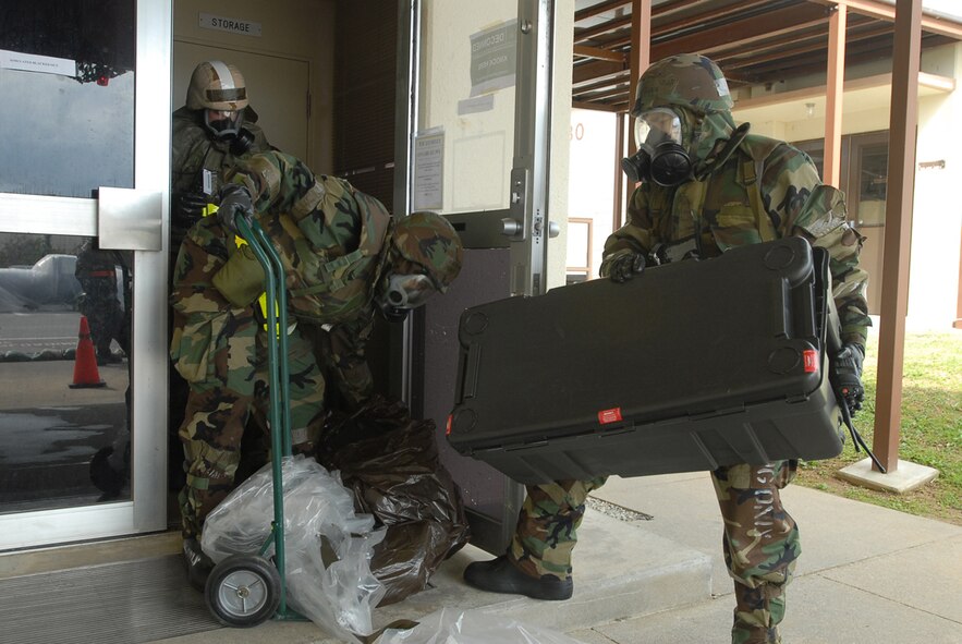 Members from the 961st Airborne Air Control Squadron exit their building with supplies after a simulated unexploded ordinance was found during local operational readiness exercise Beverly High 08-4 at Kadena Air Base, Japan, Feb. 15, 2008. The 18th Wing conducted the exercise from Feb. 10 to 15 to test Airmen's ability to respond in contingency situations. (U.S. Air Force photo/Senior Airman Darnell T. Cannady)