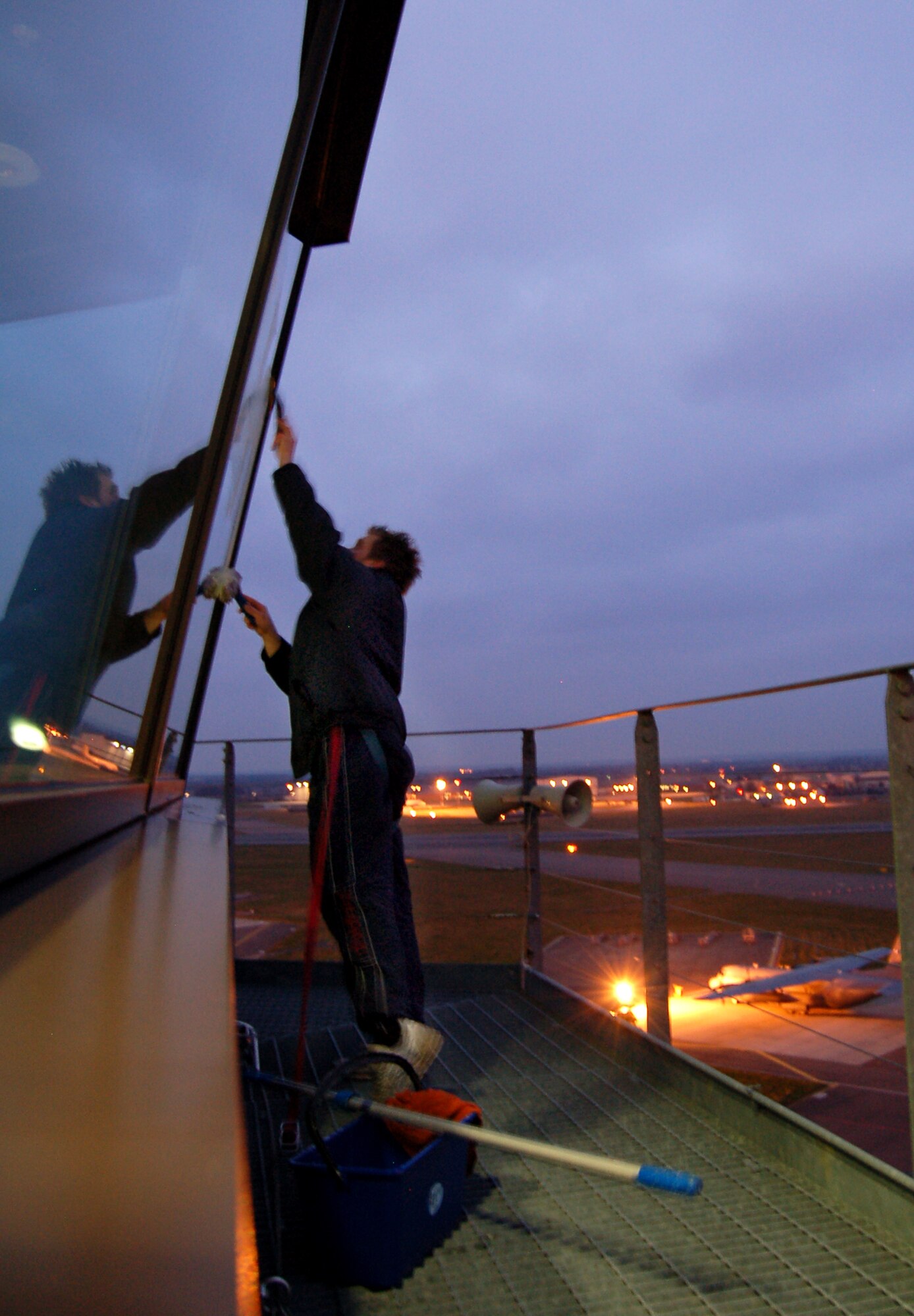 Rob Drew, cleaning contractor, wipes down the windows of the air traffic control tower in the early hours of the morning Feb. 15.  Mr. Drew has cleaned the windows of the tower every week for the last 18 months.  (U.S. Air Force photo by Tech. Sgt. Eric Petosky)