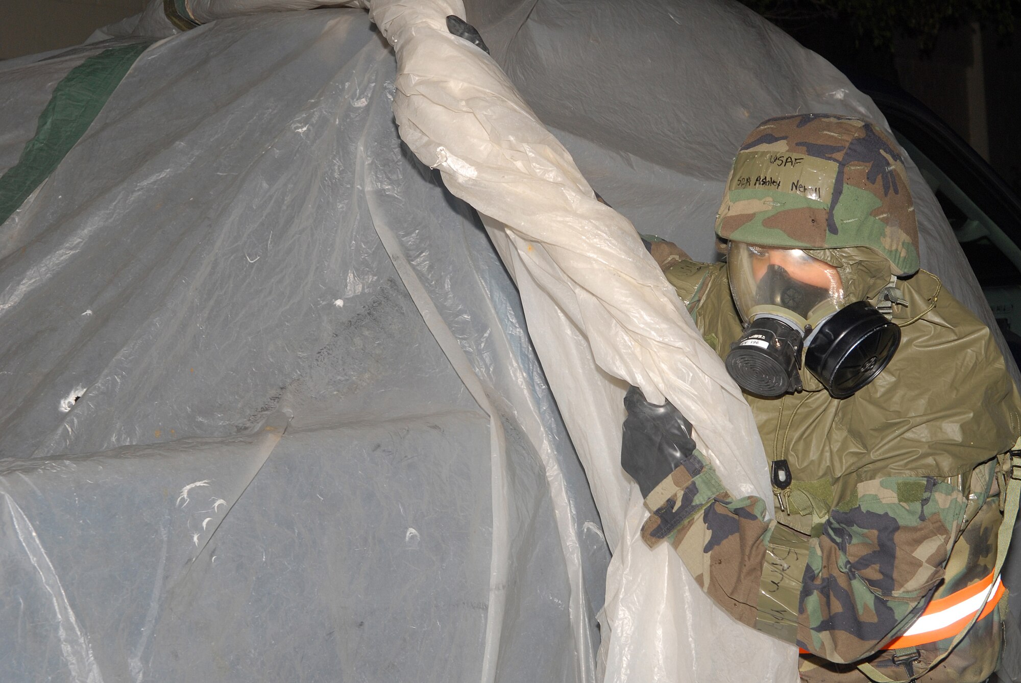 Senior Airmen Ashley Newell, 961st Airborne Air Control Squadron, removes uncontaminated plastic from a pick-up truck prior to transporting a victim to the hospital, after an attack scenario during local operational readiness exercise Beverly High 08-4 at Kadena Air Base, Japan, Feb. 14, 2008. The 18th Wing conducted the exercise from Feb. 10 to 15 to test Airmen's ability to respond in contingency situations. (U.S. Air Force photo/Staff Sgt. Chrissy FitzGerald)