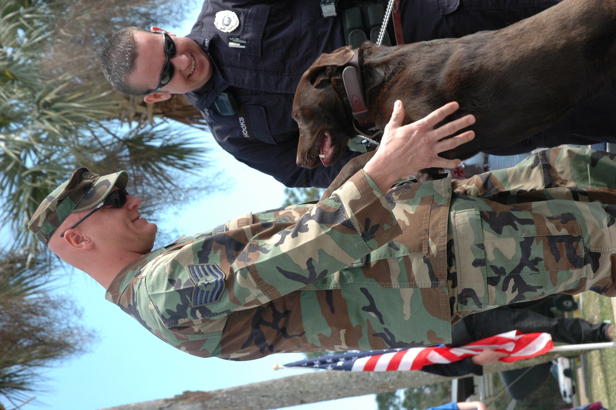 Tech. Sgt. Todd Coning, 96th Security Forces Squadron, is greeted by working dog Luke and his handler Patrolman Ryan Hooks, Niceville Police Department, before the ceremony honoring all working dogs at the Air Armanment Museum today. (USAF phot/Staff Sgt. Stacia Zachary)
