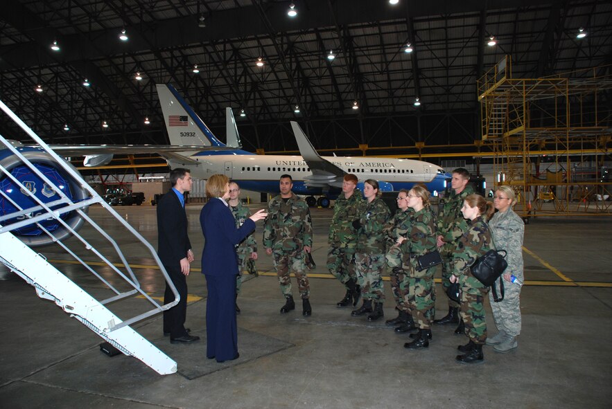 Tech. Sgt. April Tarbill and Senior Airman Bob Fourman, both flight attendants with the 73rd Airlift Squadron, 932nd Airlift Wing, speak to other Air Force Airmen about opportunities in the Air Force Reserve Command flight attendant program.In this photo they are standing at the base of a C-40C while another C-40C sits in the background.  Photo/Capt. Stan Paregien