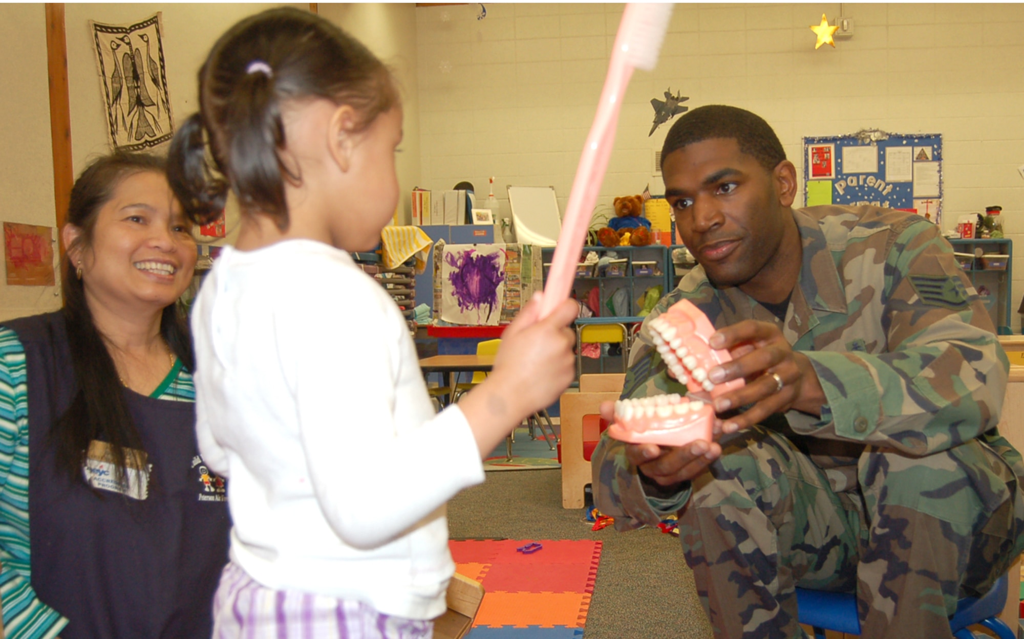 Staff Sgt. Jason Atkins talks to toddlers about dental health at the Peterson Child Development Center Annex Feb. 13. Members of the 21st Dental Squadron are visiting the CDC, the R.P. Lee Youth Center and local elementary schools this month as part of National Children’s Dental Health Month. (U.S. Air Force photo/Corey Dahl)