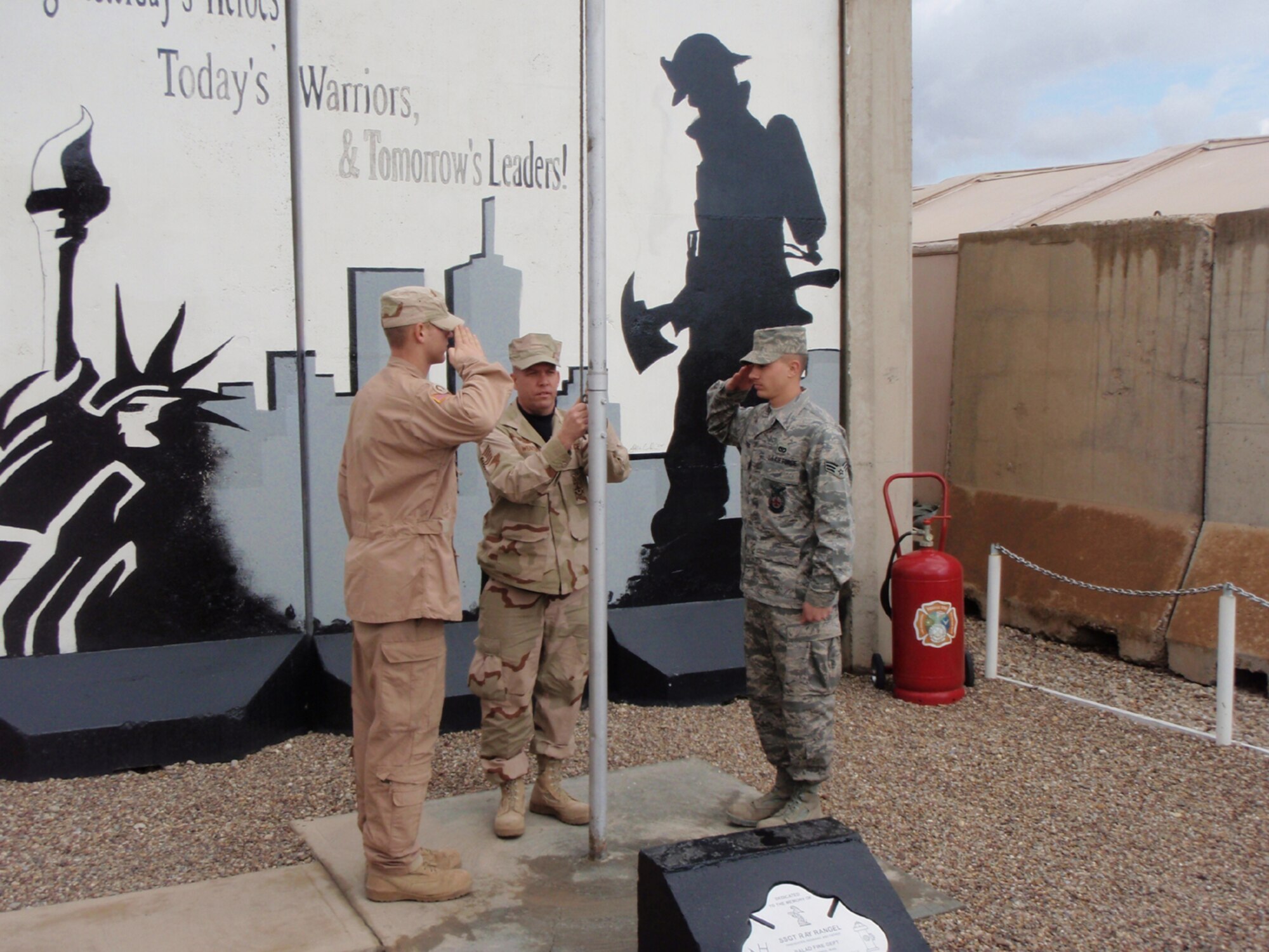 SEYMOUR JOHNSON AIR FORCE BASE, N.C. -- Tech. Sgt. Michael Wenthe (center) raises the American flag at his duty location in Balad. Sgt. Wenthe is a member of the 916th Civil Engineer Squadron and is currently deployed to Iraq as the non-commissioned officer in charge of fire training. Nearly 30 civil engineer members left their Reserve wing in North Carolina in early January.