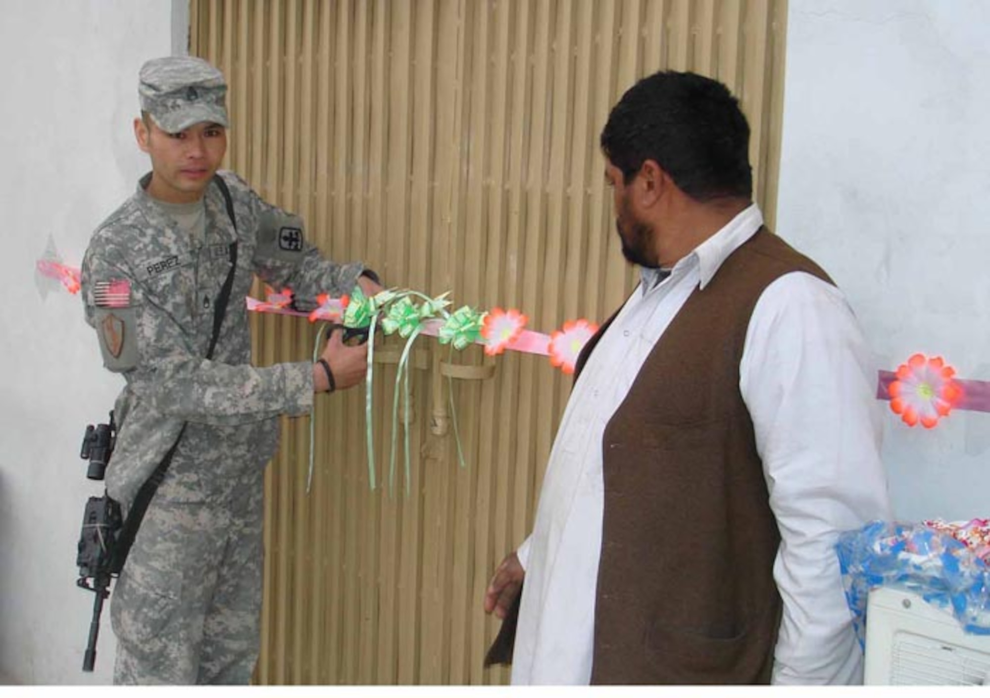LAGHMAN PROVINCE, Afghanistan – Army Staff Sgt. Alberto Perez cuts the ribbon to reopen the newly-renovated fitness center, renamed in honor of Army Staff Sgt. Charles R. Browning, here Feb. 14.  Sergeant Browning, a 1st Battalion, 158th Infantry Soldier was killed by an improvised explosive device June 1, 2007 responding to an emergency call from the local community. The Humvee he was riding in ran over the IED killing him instantly and injuring four others.  Sergeant Browning volunteered for a one-year deployment to provide security for Methar Lam Provincial Reconstruction Team to help the government of Afghanistan with its security, governance and reconstruction. (U.S. Air Force photo by Capt. Heather Kekic)