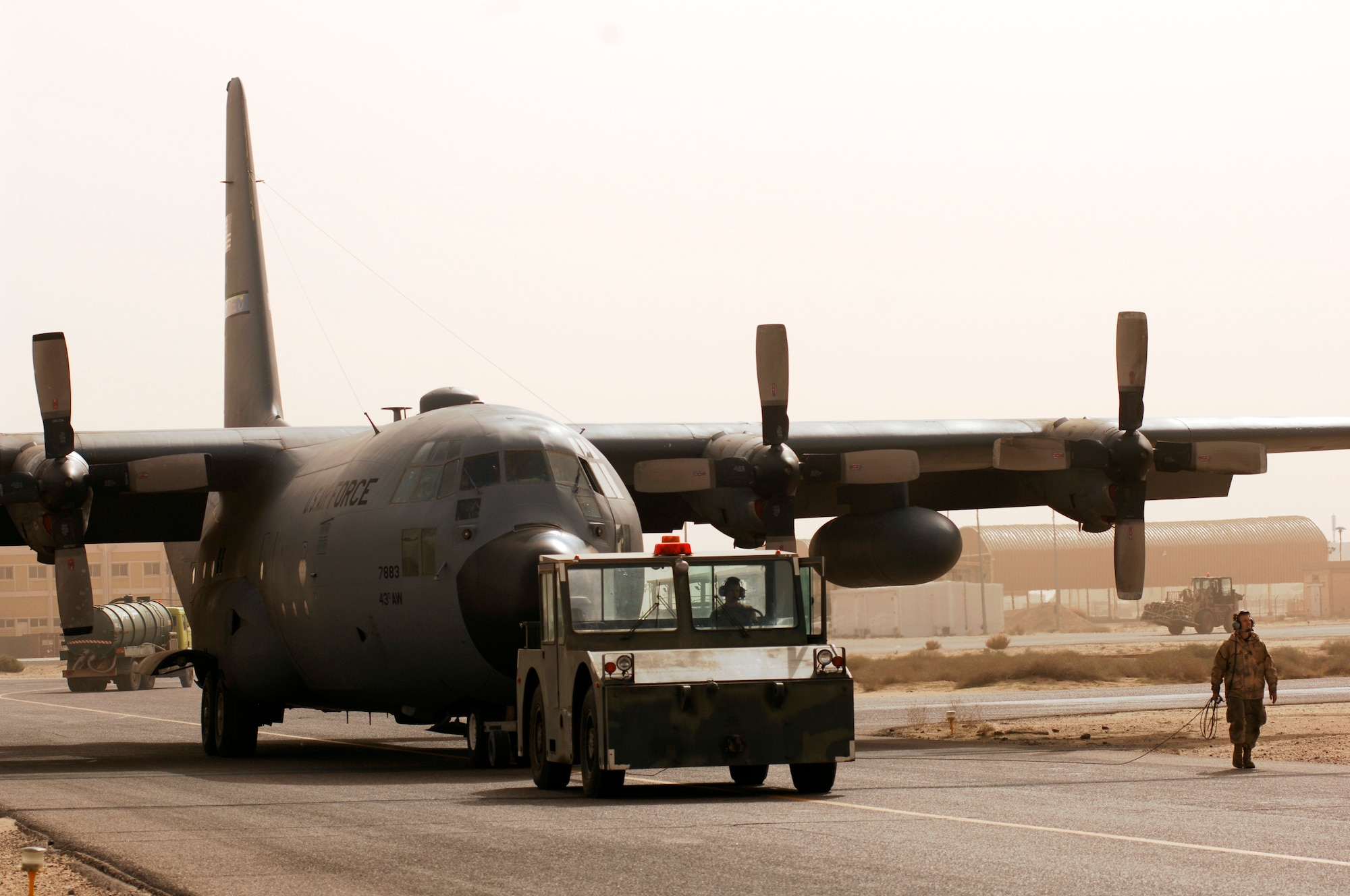 SOUTHWEST ASIA -- Senior Airman William Ashton, a C-130 crew chief deployed to the 386th Expeditionary Aircraft Maintenance Squadron, is wing-walking for fellow crew chief Senior Airman Justin Brown who’s sitting in the tow vehicle operator seat on a Southwest Asia air base Jan. 31, 2008. Airman Ashton is ensuring the wingtips do not strike any objects while it is in tow. Airmen Ashton and Brown are deployed from Pope Air Force Base, S.C., in support of Operations Enduring and Iraqi Freedom. (U.S. Air Force photo/ Staff Sgt. Patrick Dixon)