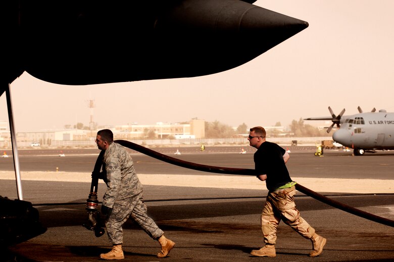 SOUTHWEST ASIA -- Senior Airman Mark Applewhite, (right), a crew chief deployed to the 386th Expeditionary Aircraft Maintenance Squadron, assists Senior Airman Bryan Gallagher, a petroleum, oil, and lubricant—fuels specialist deployed to the 386th Expeditionary Logistics Readiness Squadron, with refueling a C-130 Hercules aircraft on a Southwest Asia air base Jan. 31, 2008. Airman Applewhite is deployed from Ramstein Air Base, Germany and Airman Gallagher is deployed from McGuire Air Force Base, N.J., in support of Operations Enduring and Iraqi Freedom. (U.S. Air Force photo/ Staff Sgt. Patrick Dixon)