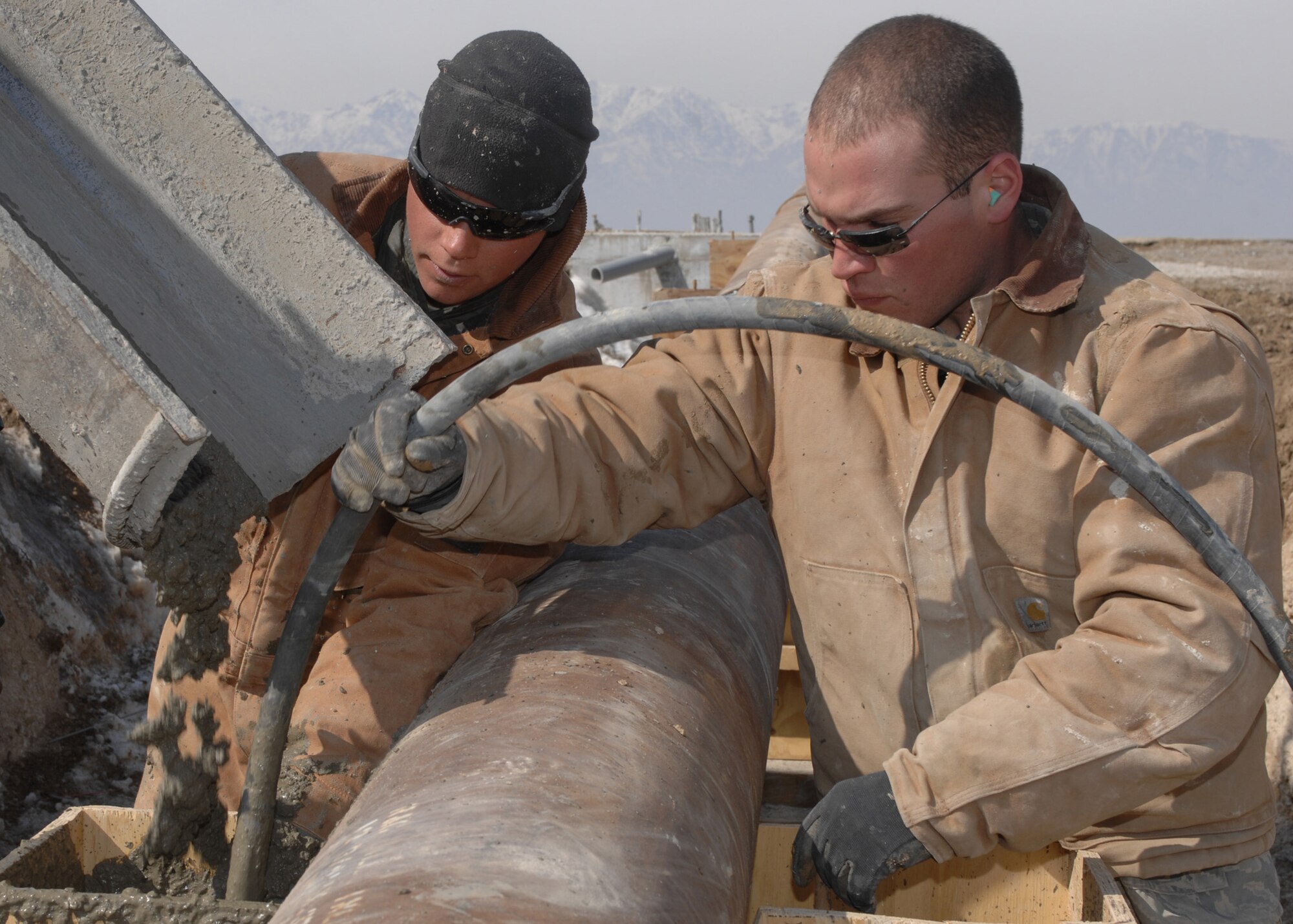BAGRAM AIR BASE, Afghanistan - Senior Airman Steven Moss, 1st Expeditionary RED HORSE Group structural journeyman, and Staff Sgt. Jorge Zequeira, 1st Expeditionary REDHORSE Group power production journeyman, pump cement while working construction on a barrier arresting kit here Feb. 13. Once the BAK 12 is finished, it will be used to stop aircraft with tail hooks that have hydraulics or brake problems . Moss (left) is from 819th RED HORSE Squadron, Malmstrom Air Force Base, Mont., and Zequeira's home unit is the 11th Civil Engineering Squadron at Bolling Air Force Base, D.C. (U.S. Air Force photo by Master Sgt. Demetrius Lester)