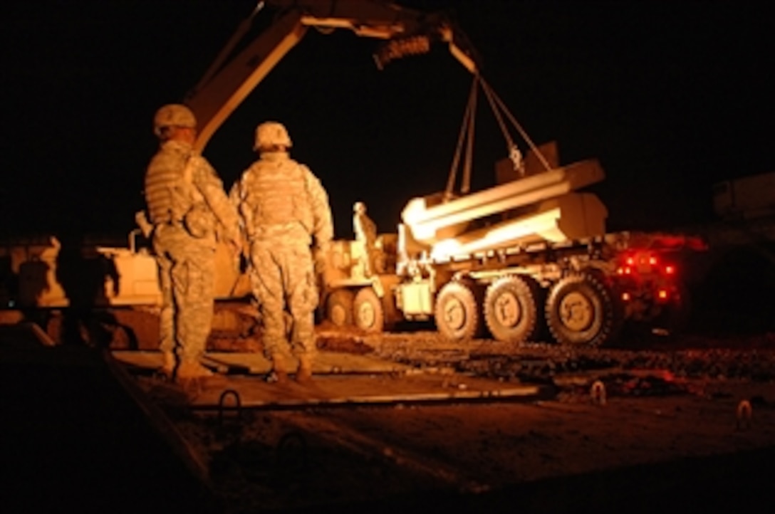 U.S. soldiers from 77th Engineer Company, 94th Engineer Battalion, work throughout the night to construct a new combat outpost in Mosul, Iraq, Feb. 14, 2008. The outpost is being constructed in the Rissala traffic circle, one of the most dangerous areas of the city, and will aid as a stronghold against insurgency in the area. 