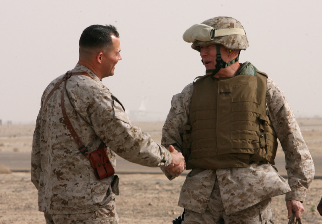 The Commandant of the Marine Corps General James T. Conway shakes hands with Brig. Gen. Robert R. Ruark, commanding general, 1st Marine Logistics Group upon arriving to Camp Al Taqaddum for a brief visit Monday.