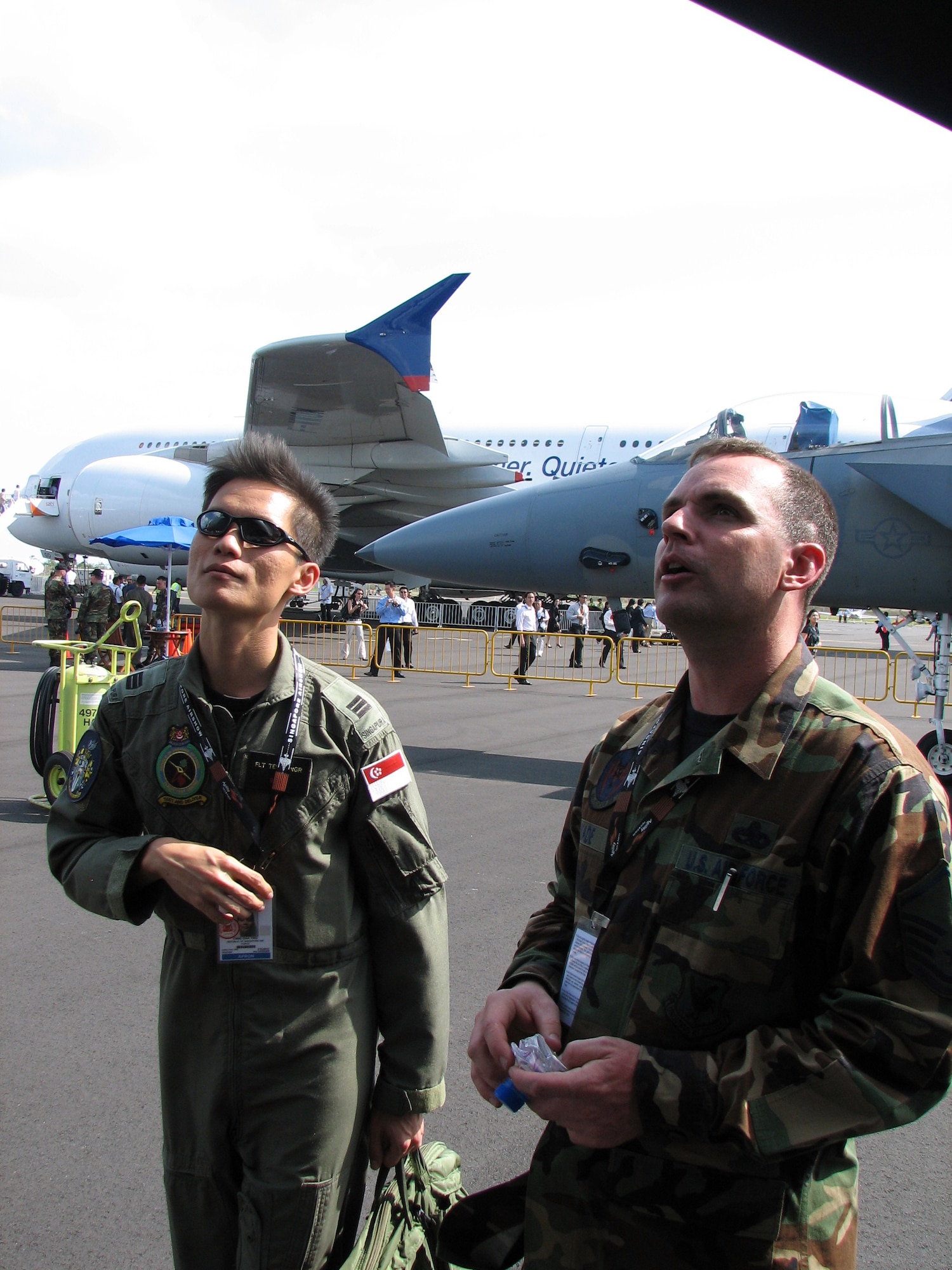 Master Sgt. David Wade, a maintenance section chief from the 18 Aircraft Maintenance Squadron, Kadena Air Base, Japan, shows Singapore Air Force Test Pilot Capt. Chng Chia Ying around an F-15C during the Singapore International Air Show Feb. 19.  A cross-section of U.S. military aircraft and equipment are on static display to include F-15C, F-16CJ and F/A-18C multi-role fighters, a WC-130J weather reconnaissance aircraft, KC-135 tanker and B-1B bomber.  (U.S. Air Force photo by Senior Master Sgt. Charles Ramey)