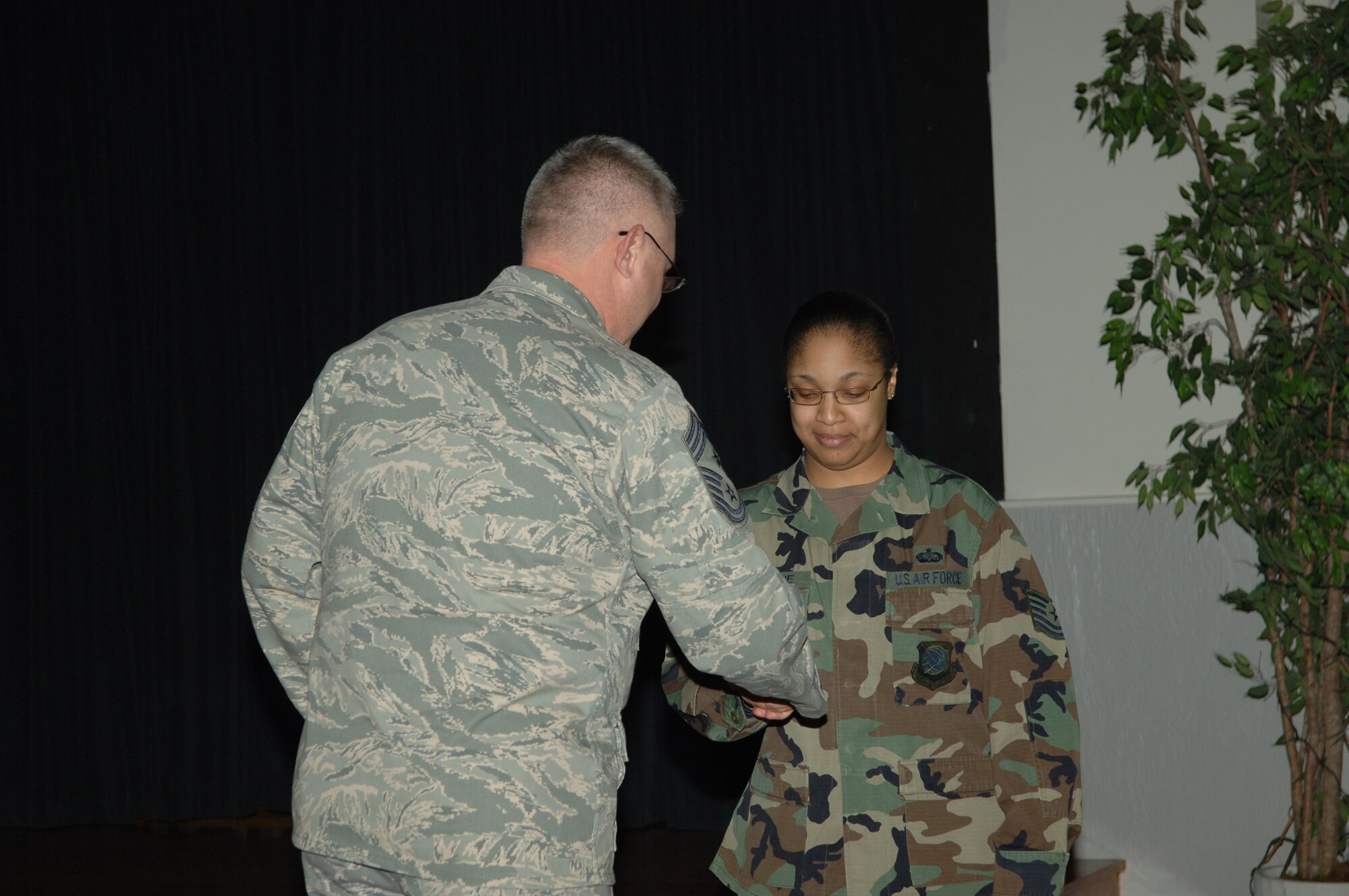 FAIRCHILD AIR FORCE BASE, Wash. – 92nd Air Refueling Wing command chief Paul Sikora coins Tech. Sgt. Miranda McKenzie, 92nd Services Squadron, at the Deel Community Center here Feb. 15. Sergeant McKenzie received a coin on behalf of the wing commander and command chief for her service to mortuary affairs and the honor guard. (U.S. Air Force photo / Senior Airman Jocelyn Ford)
