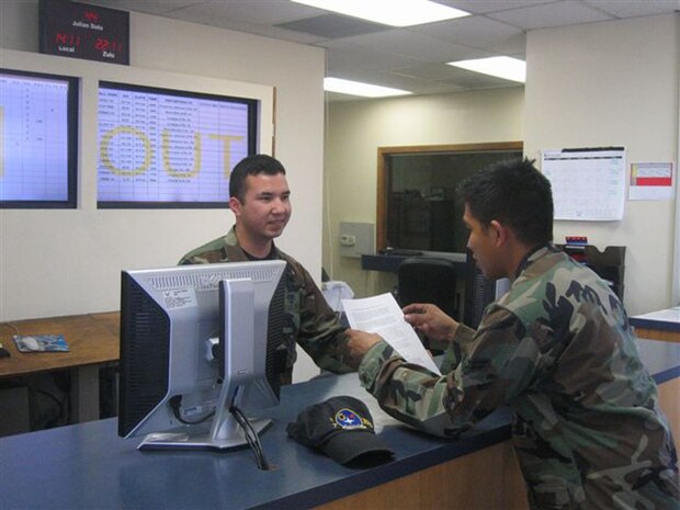 NELLIS AIR FORCE BASE, Nev.—Airman 1st Class Adam Arvizu, 99th Logistics Readiness Squadron, air transportation journeyman, explains the Space available travel policy change to Airman 1st Class Paul Capili, 57th Equipment Maintenance Squadron, equipment maintenance crew member, Feb. 13. (U.S. Air Force photo by Senior Airman Amber Harman)