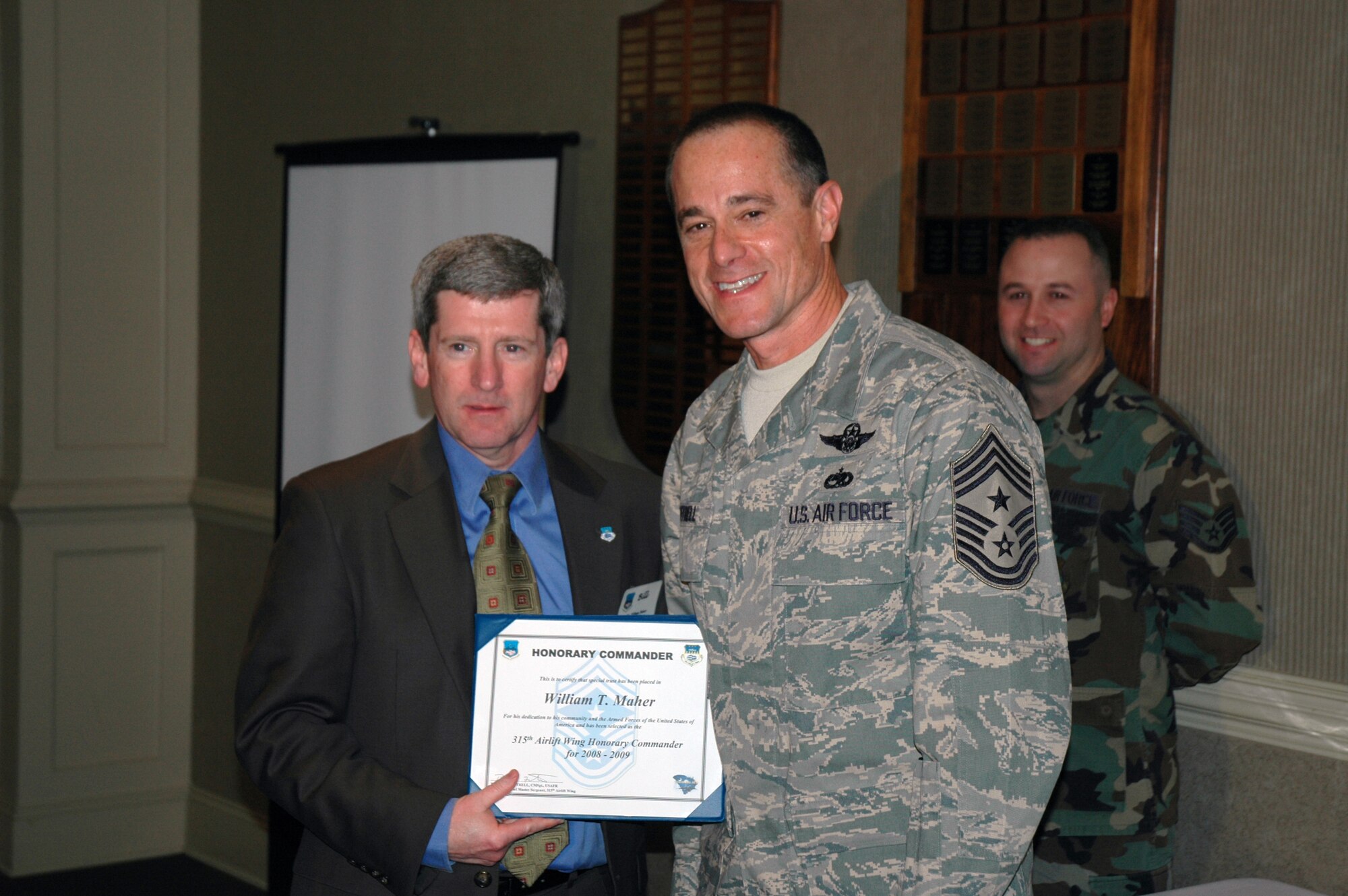 Bill Maher (left) is presented a certificate by Chief Master Sgt. Ben Futrell, the 315th Airlift Wing command chief master sergeant in a ceremony recognizing a new group of honorary commanders.  (Photo by Capt. Wayne Capps, USAFR)