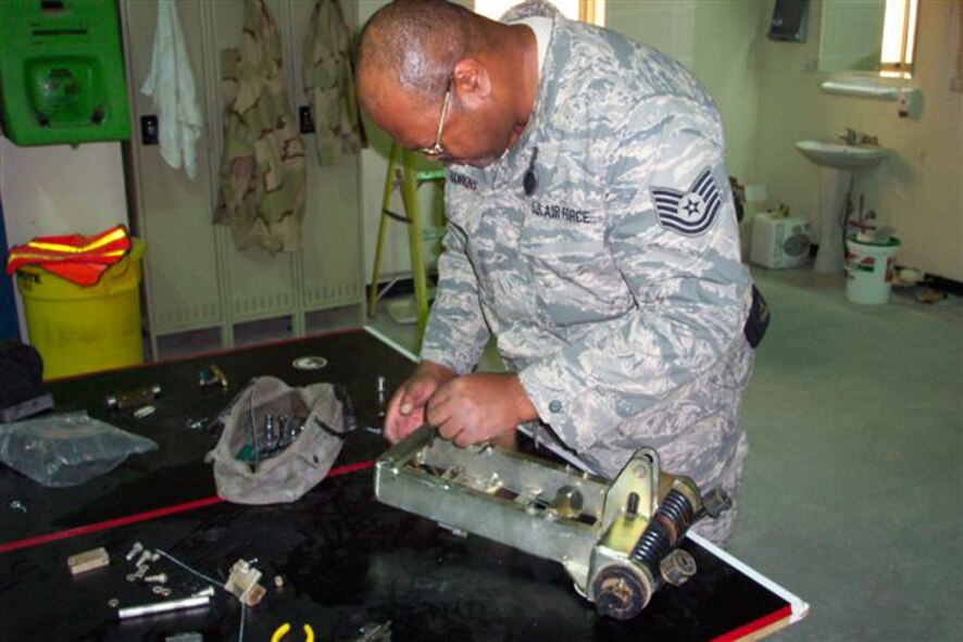 SEYMOUR JOHNSON AIR FORCE BASE, N.C. -- Tech. Sgt. Stewart Hawkins, a reservist with the 916th Civil Engineer Squadron, works on a BAK-14 retractable hook-cable support system for use with aircraft arresting systems. Sergeant Hawkins is currently deployed to Al Udeid, Qatar as a power production craftsman.